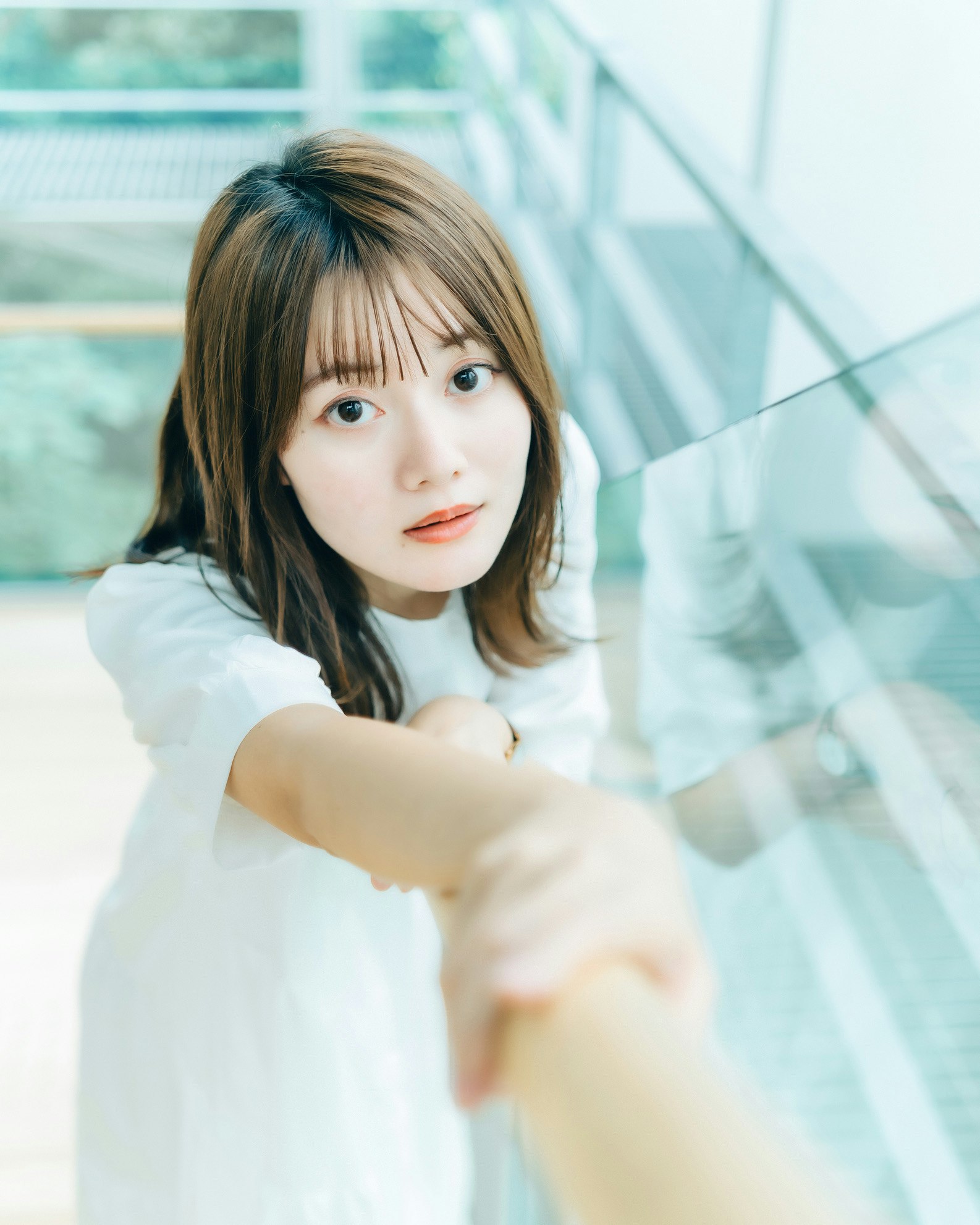Portrait of a woman smiling in front of a staircase railing