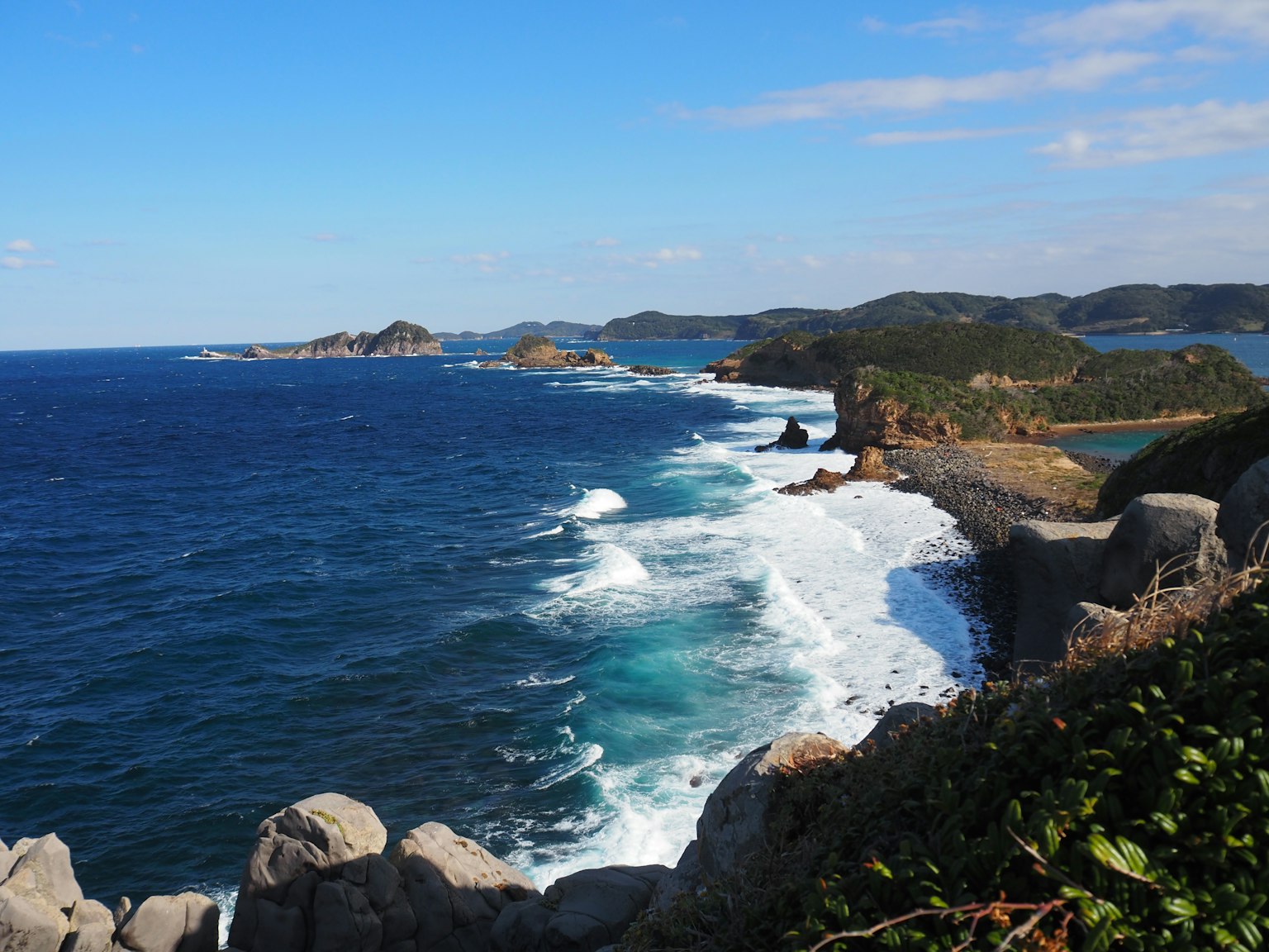 Pemandangan pantai yang indah dengan ombak yang menghantam dan laut biru