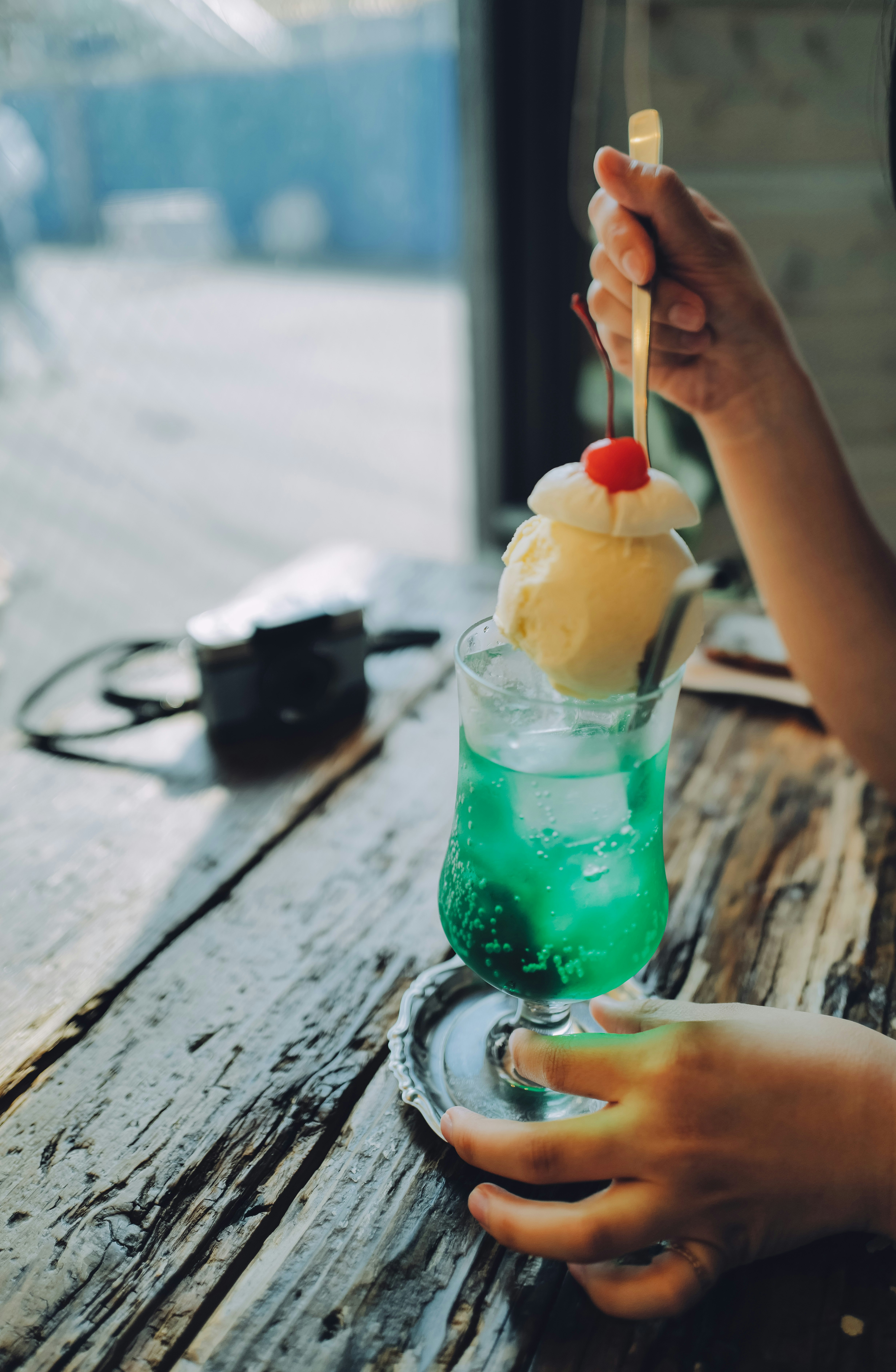 手拿木桌上的綠色蠟燭飲品