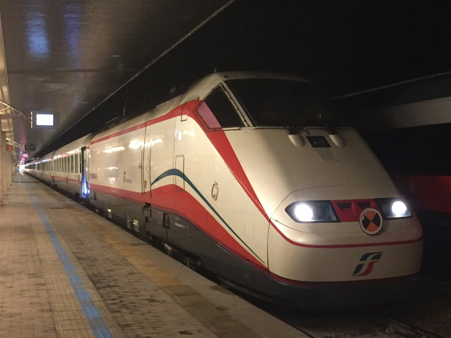 รถไฟความเร็วสูงสีขาวและแดงจอดอยู่ที่สถานี