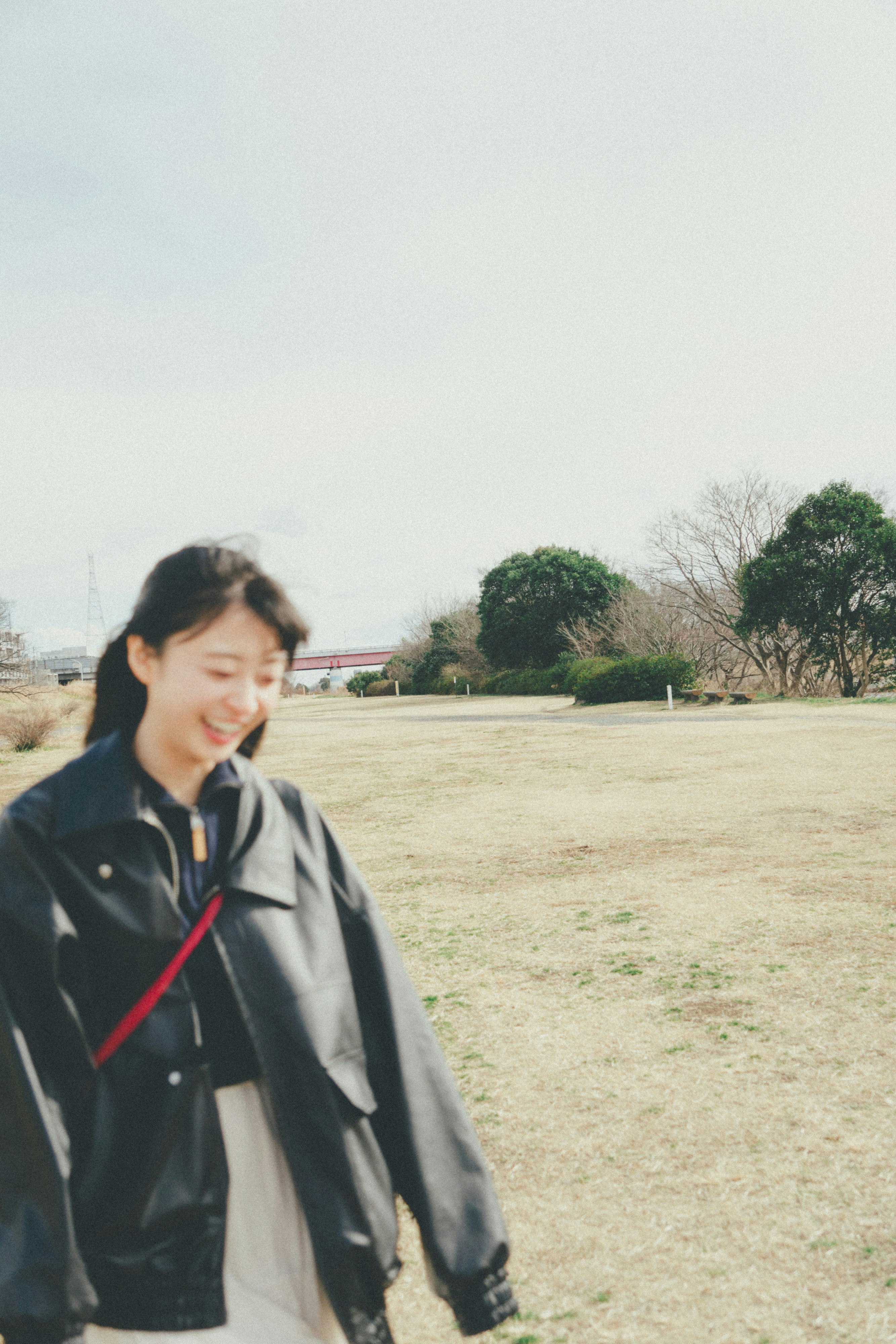 広い空き地で微笑む女性