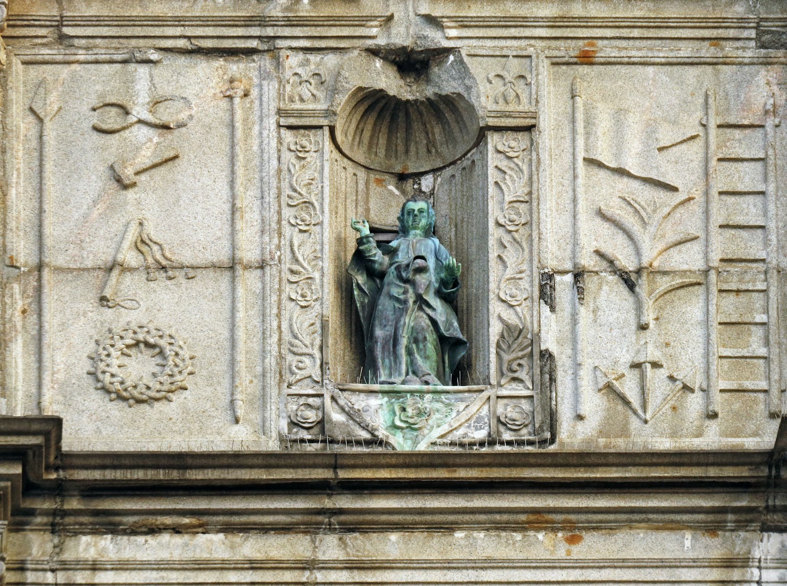 Statua su un muro di un edificio con incisioni e decorazioni classiche