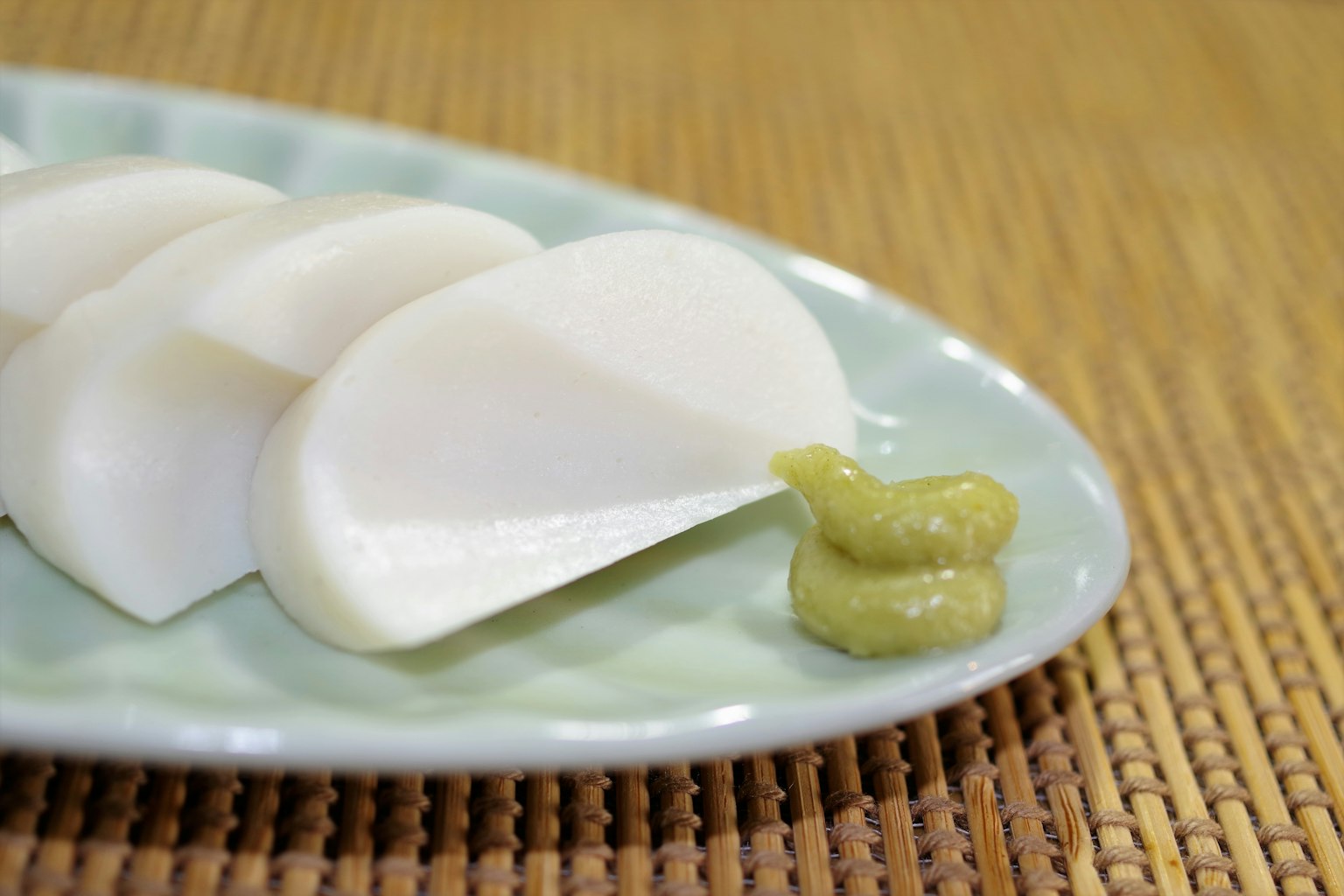 Ravanello bianco affettato servito con wasabi su un piatto