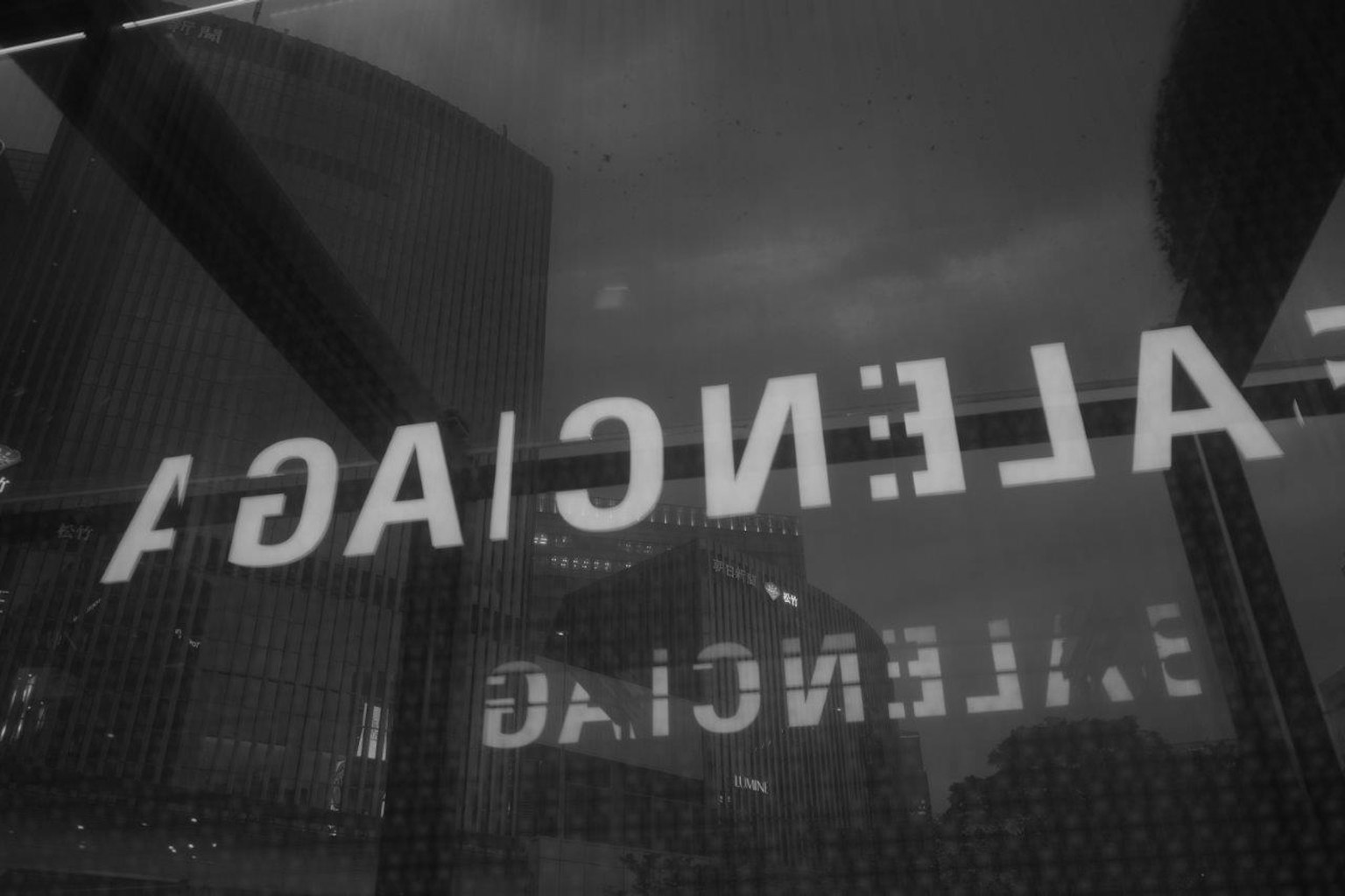 Reflection of white text on a black background in an urban setting