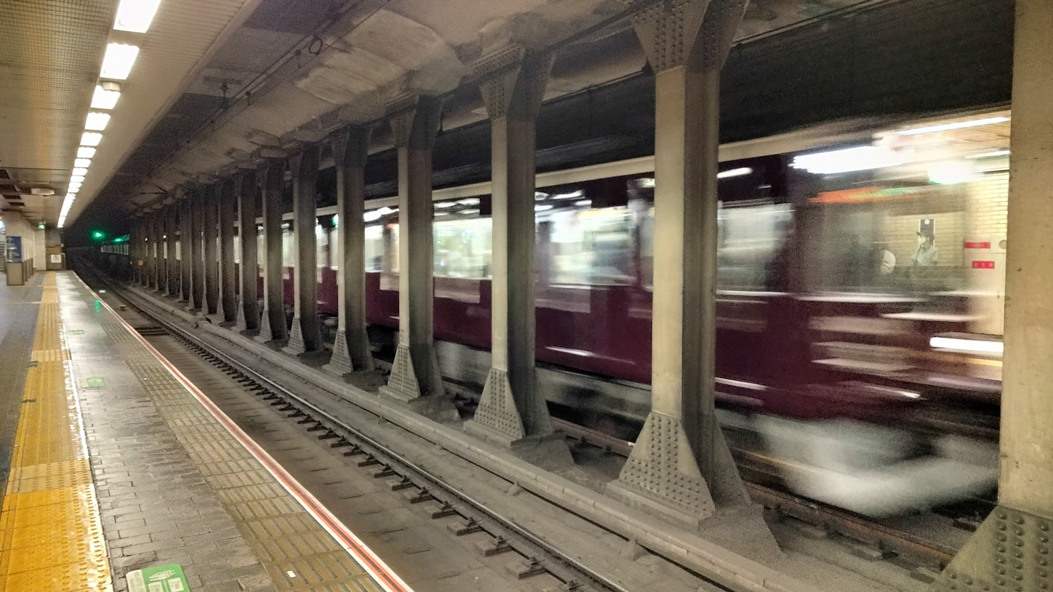 U-Bahn-Station mit einem fahrenden Zug und markanten Säulen
