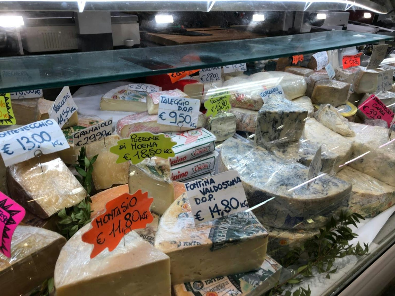 Vetrina di formaggi con vari tipi di formaggi e etichette dei prezzi