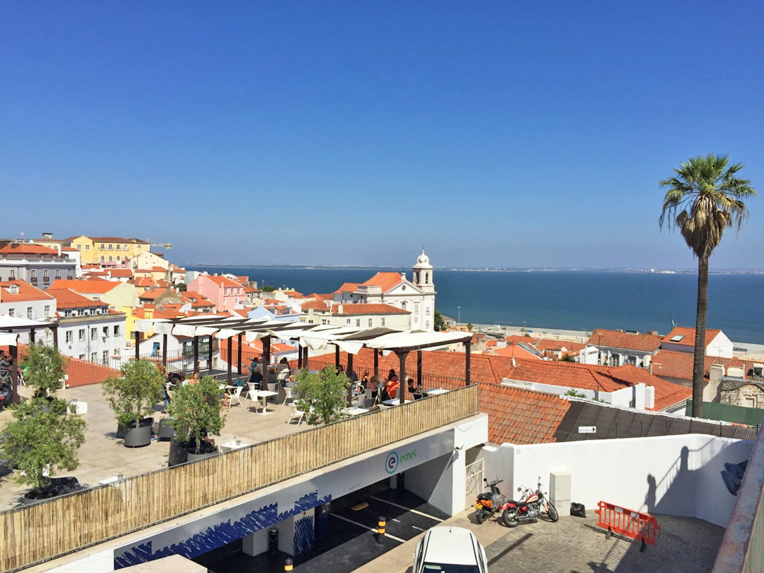 Lisbon coastline with red-roofed buildings and clear blue sky
