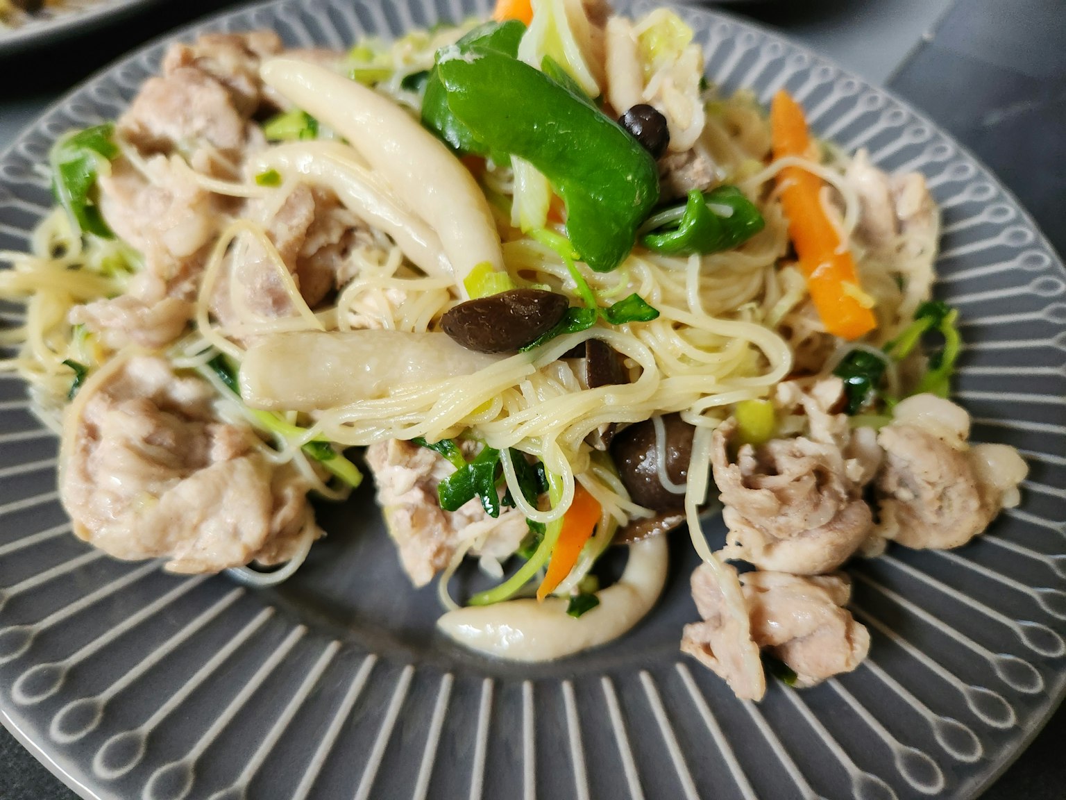 盘子里的炒鸡肉和蔬菜配米粉