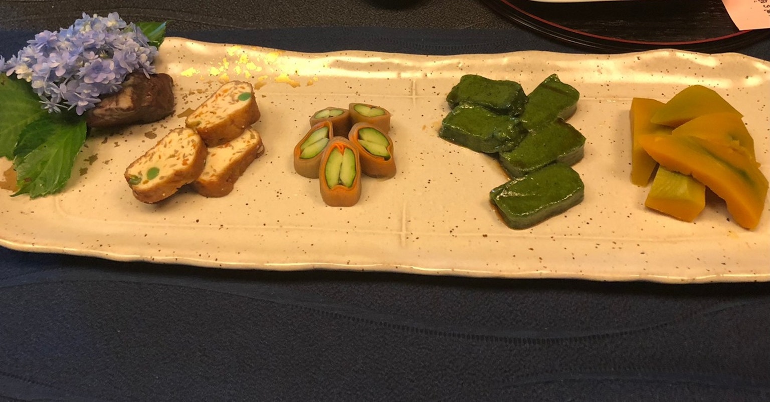 Bell'assortimento di dolci giapponesi disposto su un piatto con fiori e foglie