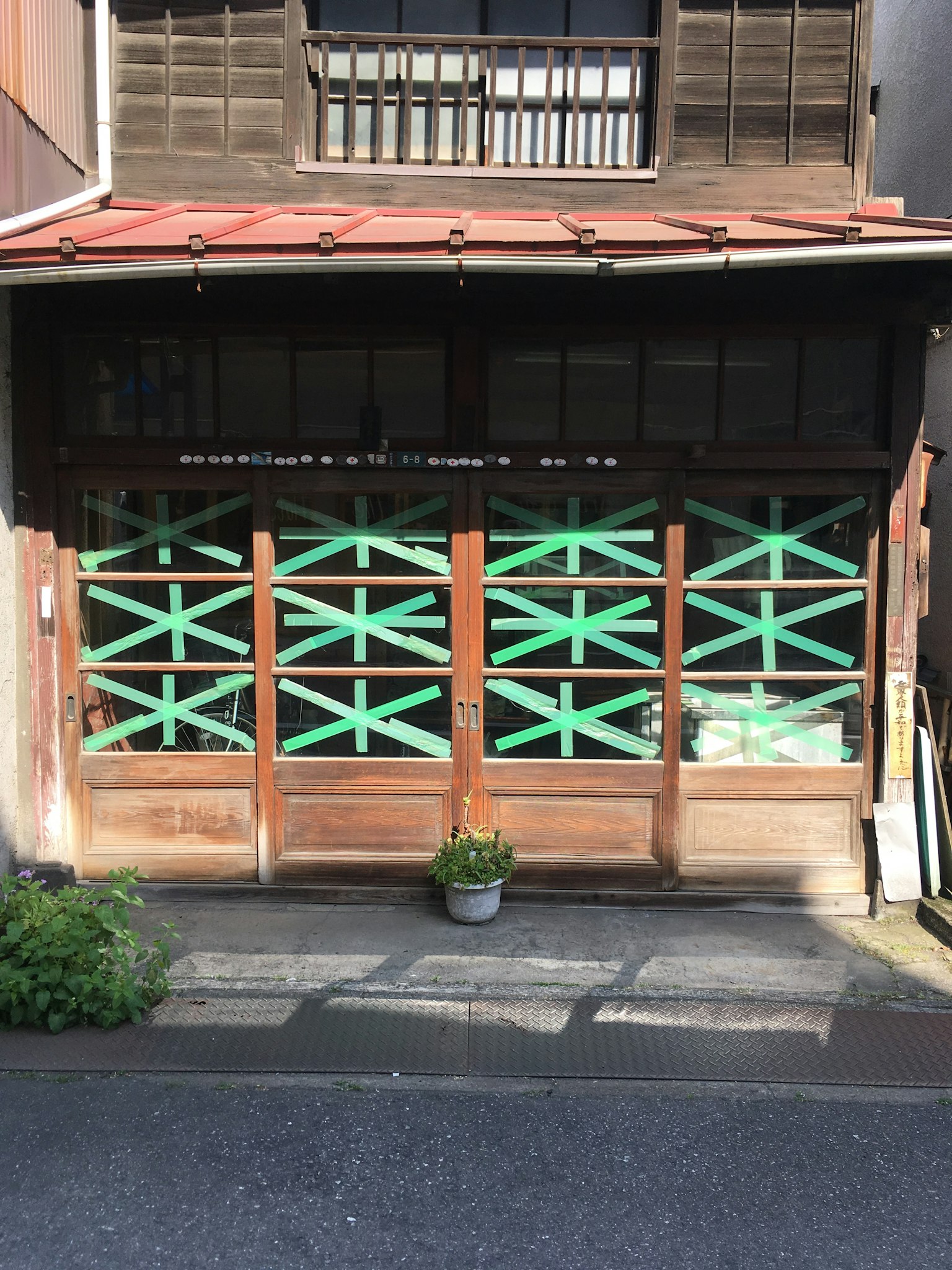 传统日本房屋外观，木门上有绿色斜条纹