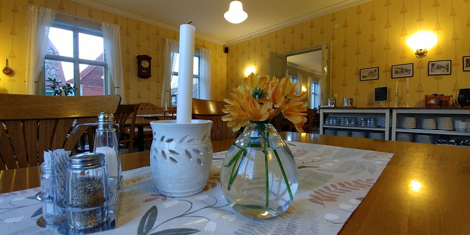Accogliente sala da pranzo con un tavolo con un vaso e una candela