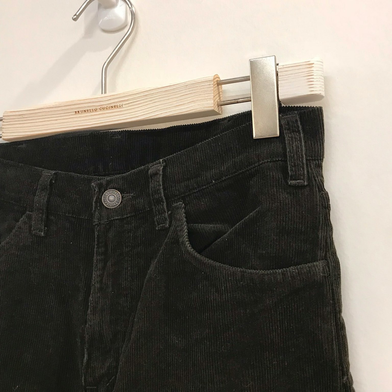 Celana corduroy hijau tua menggantung di gantungan