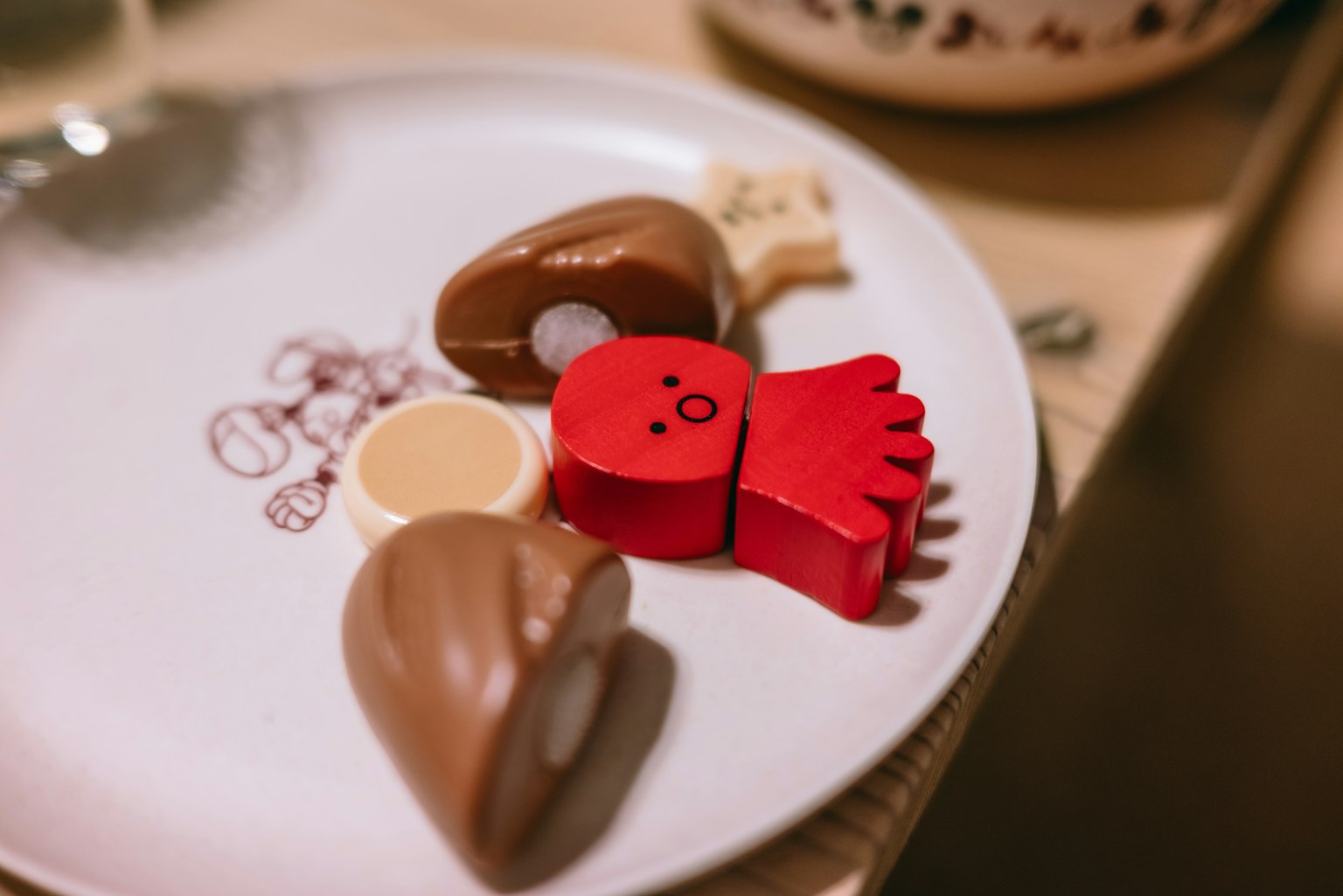 Bonbons colorés en forme de personnage rouge et friandises en chocolat disposés sur une assiette