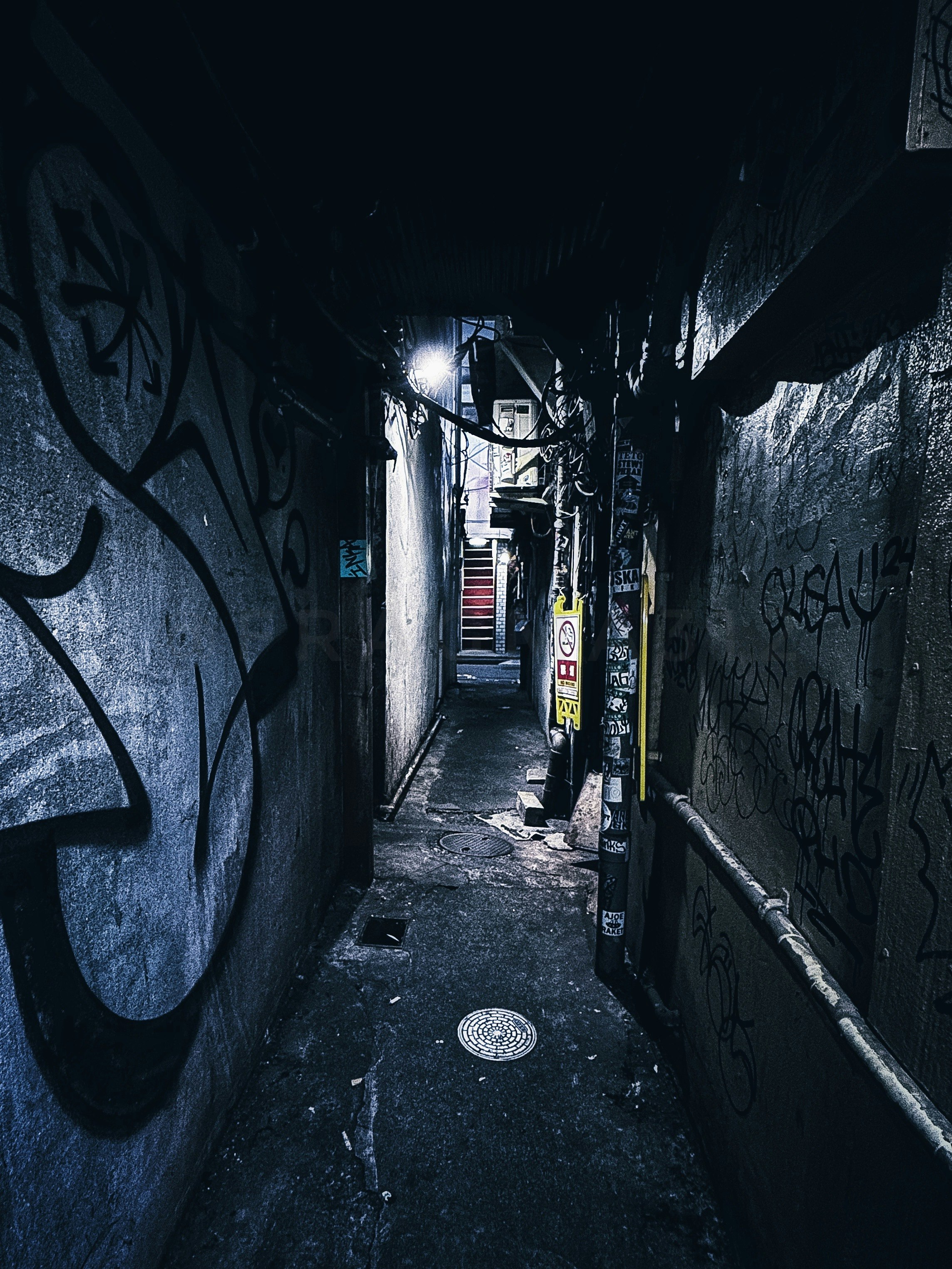 passage de ruelle de nuit aux murs couverts de graffitis