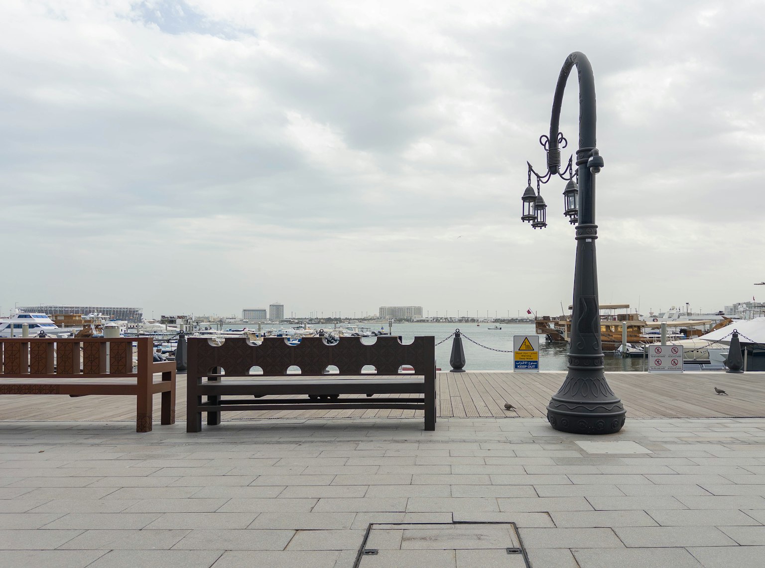Vista costera con un banco de madera y una farola