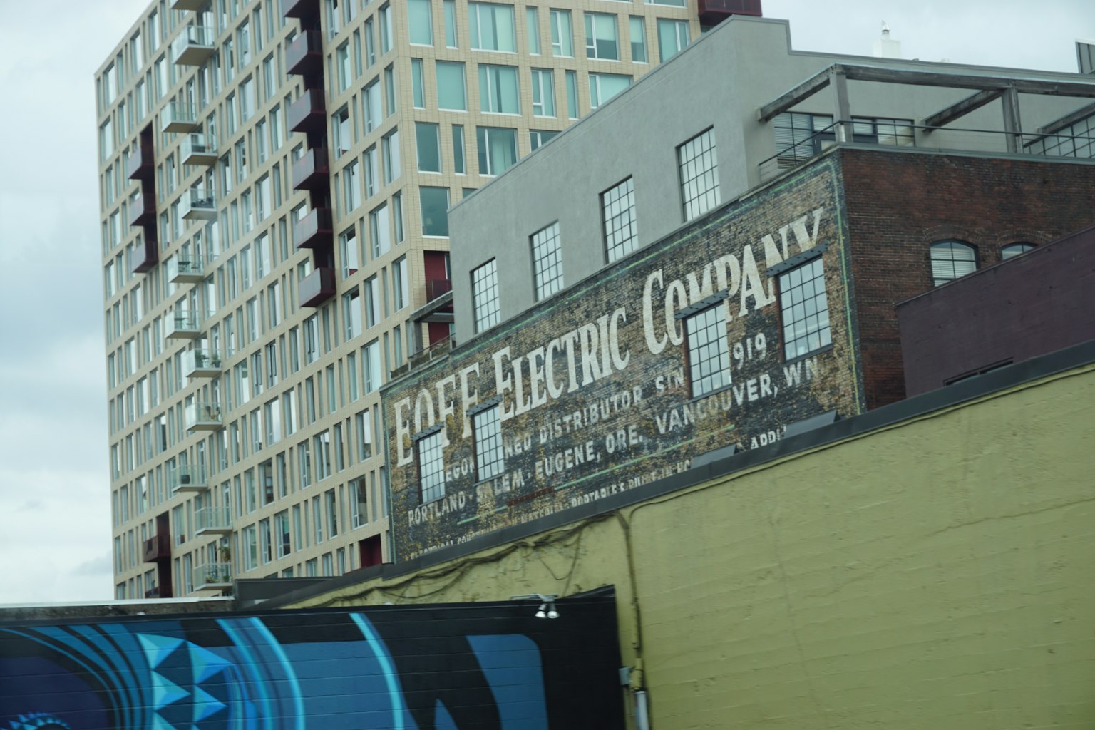 Vintage electric company sign on a wall with a modern building behind