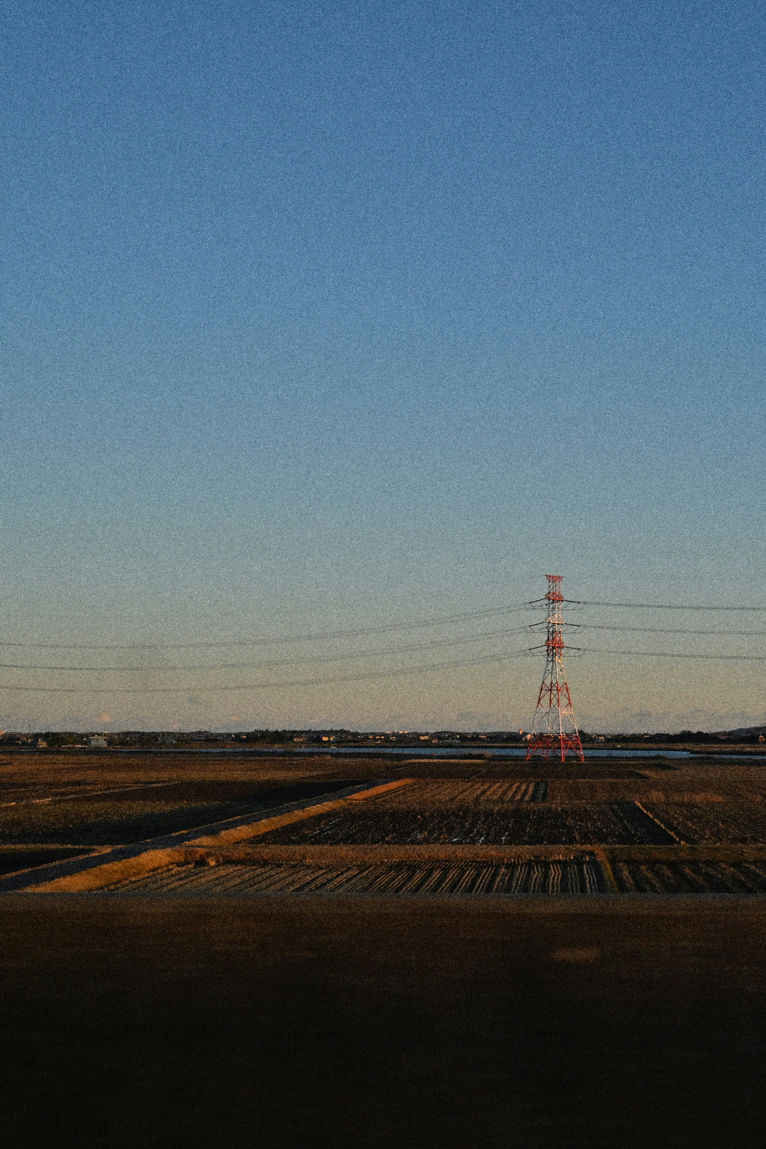 広い荒野の道路と送電鉄塔のある風景