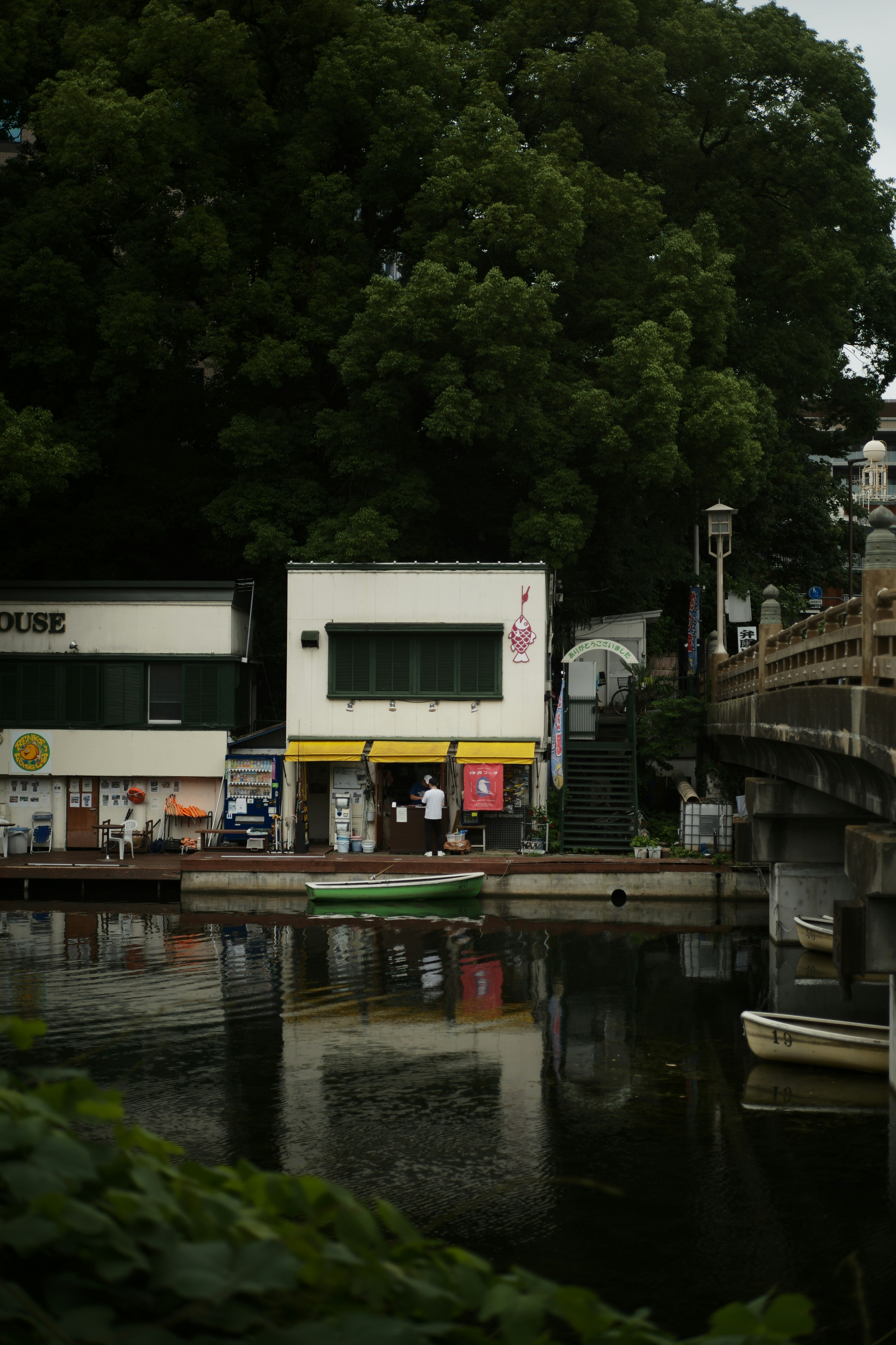 静かな水辺に面した小さな建物とボートハウス