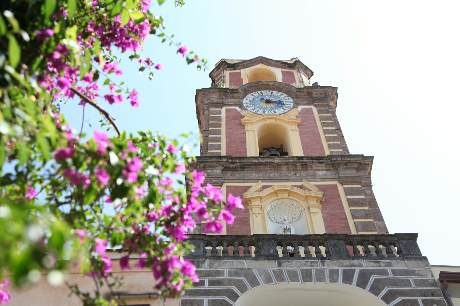 Photo d'une tour de l'horloge ornée de fleurs vibrantes