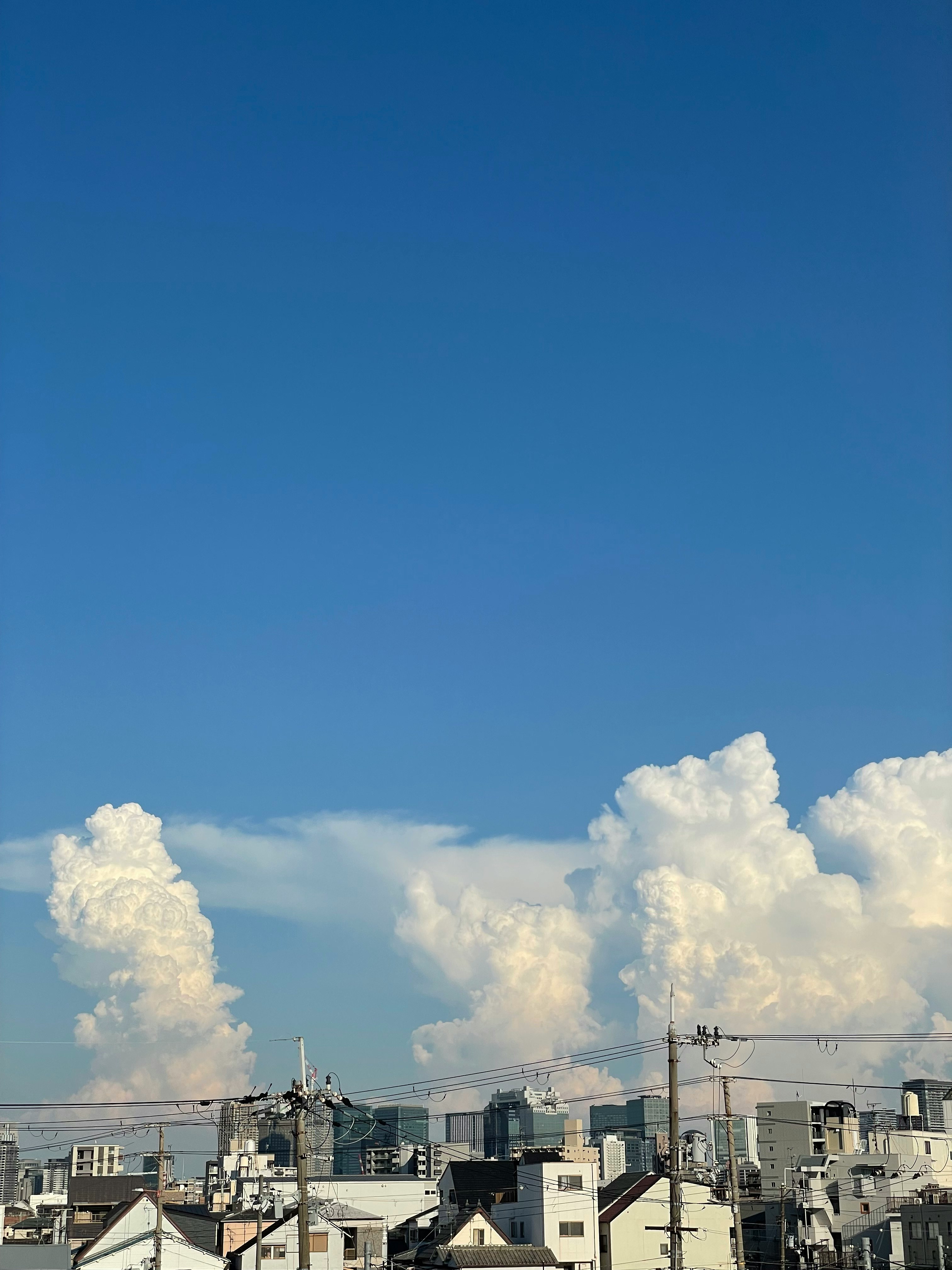 青空の下に広がる都市の屋上と煙突のある工業エリア