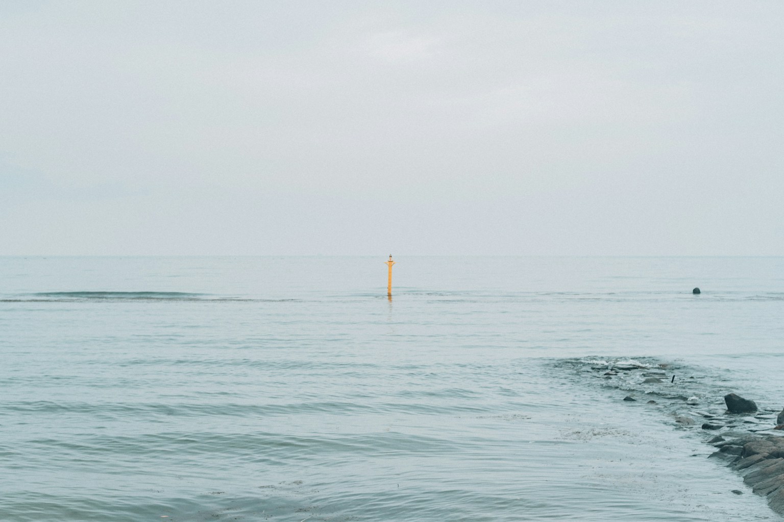 平靜的海面上有一個橙色浮標
