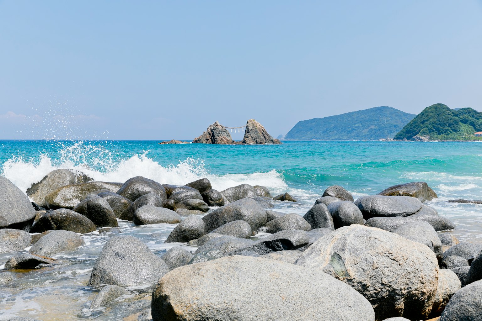 Vue panoramique d'une plage avec de l'eau bleue et des rochers