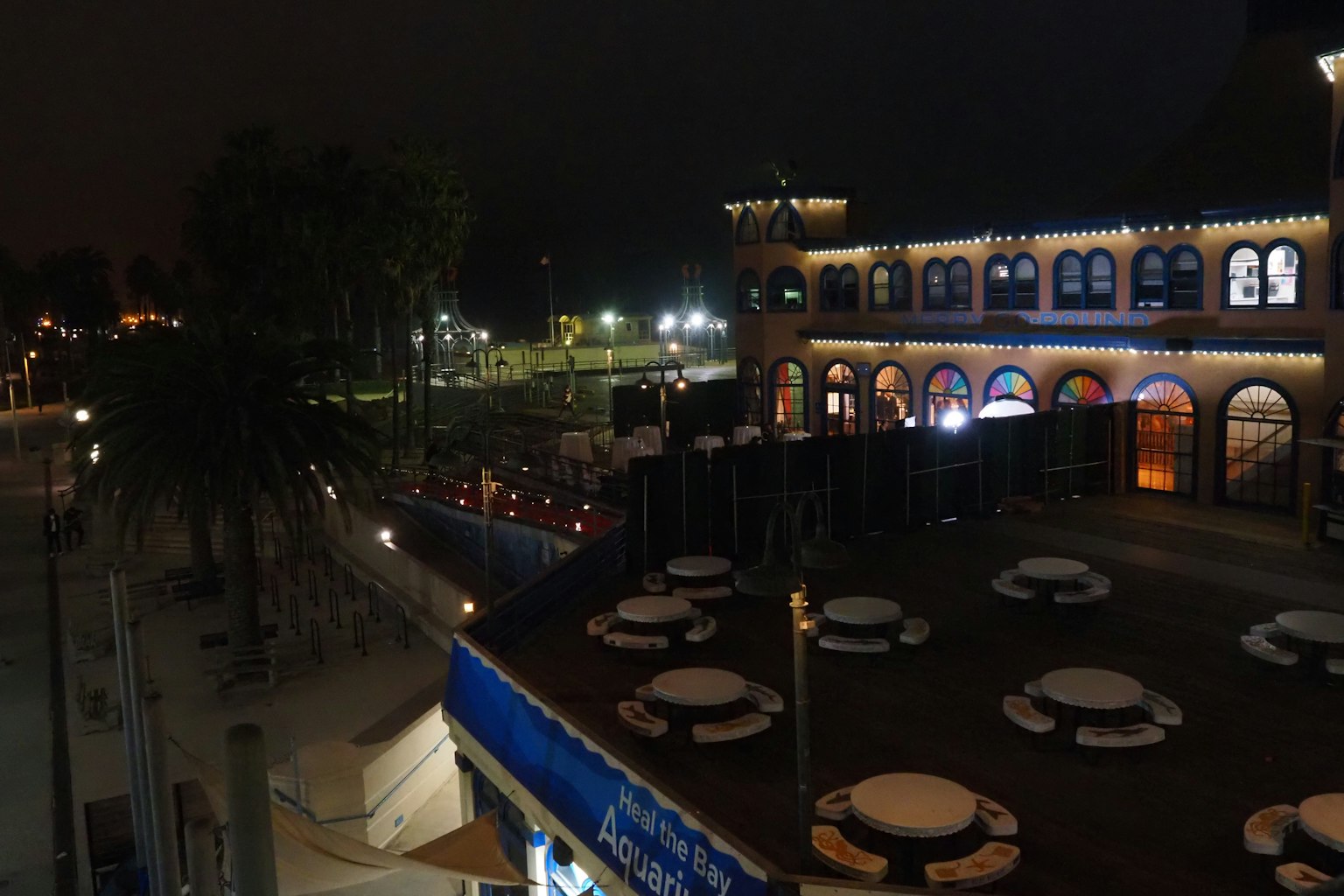 Night view of a restaurant terrace with illuminated buildings