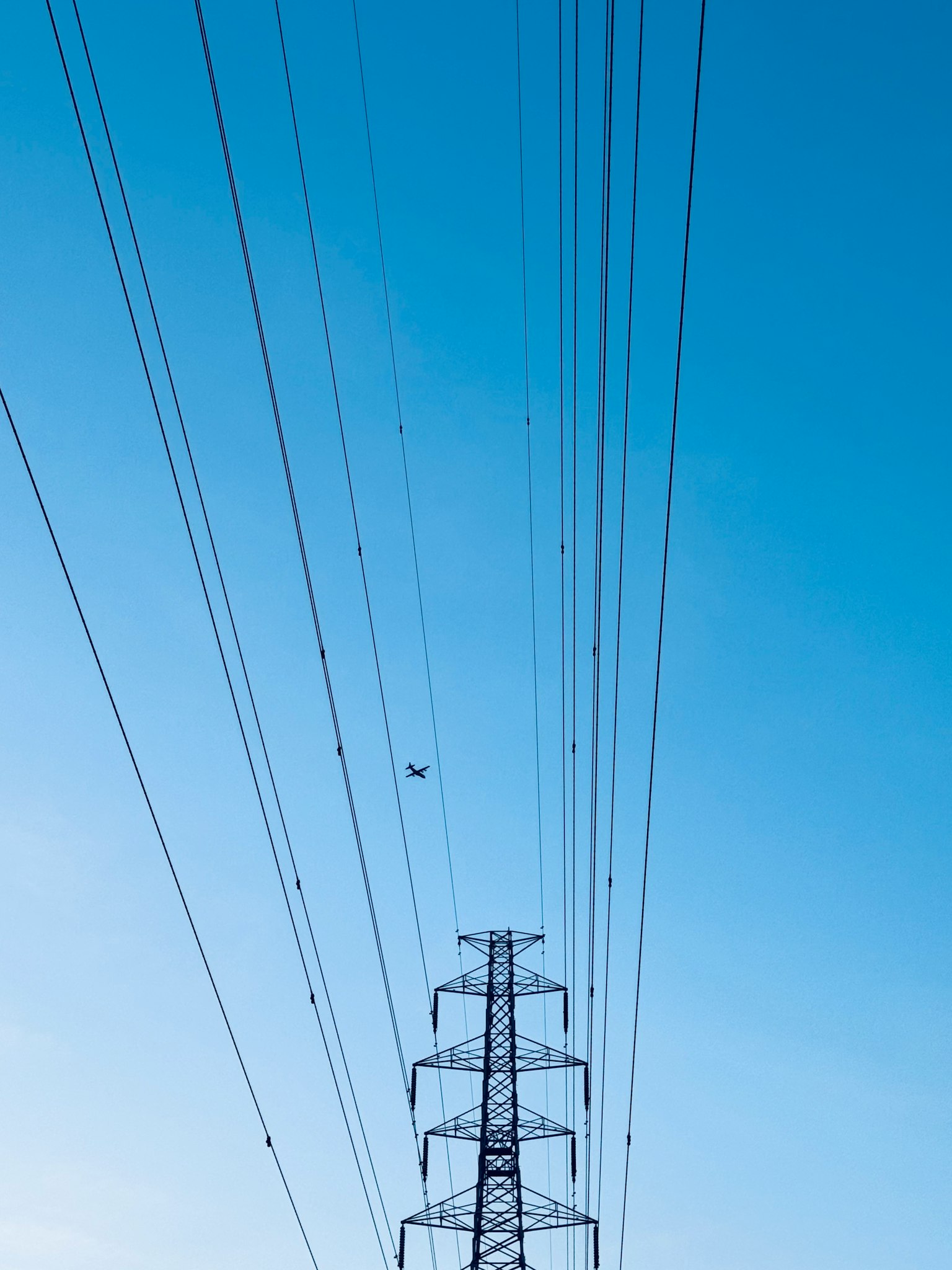 Linee elettriche ad alta tensione e torre contro un cielo blu