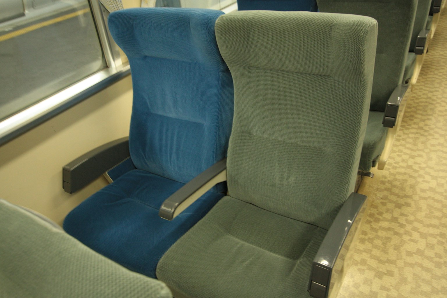 Interno di un treno con sedili in tessuto blu e verde