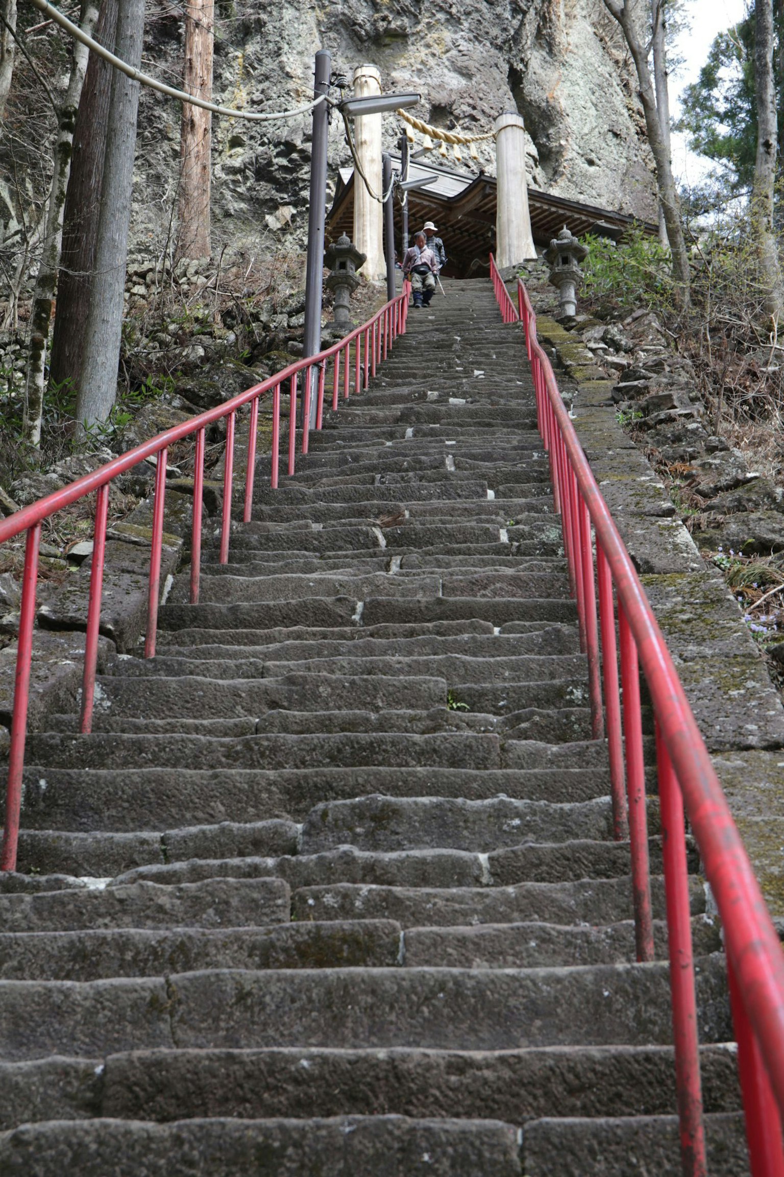 Stone steps with red railing leading up a mountain path