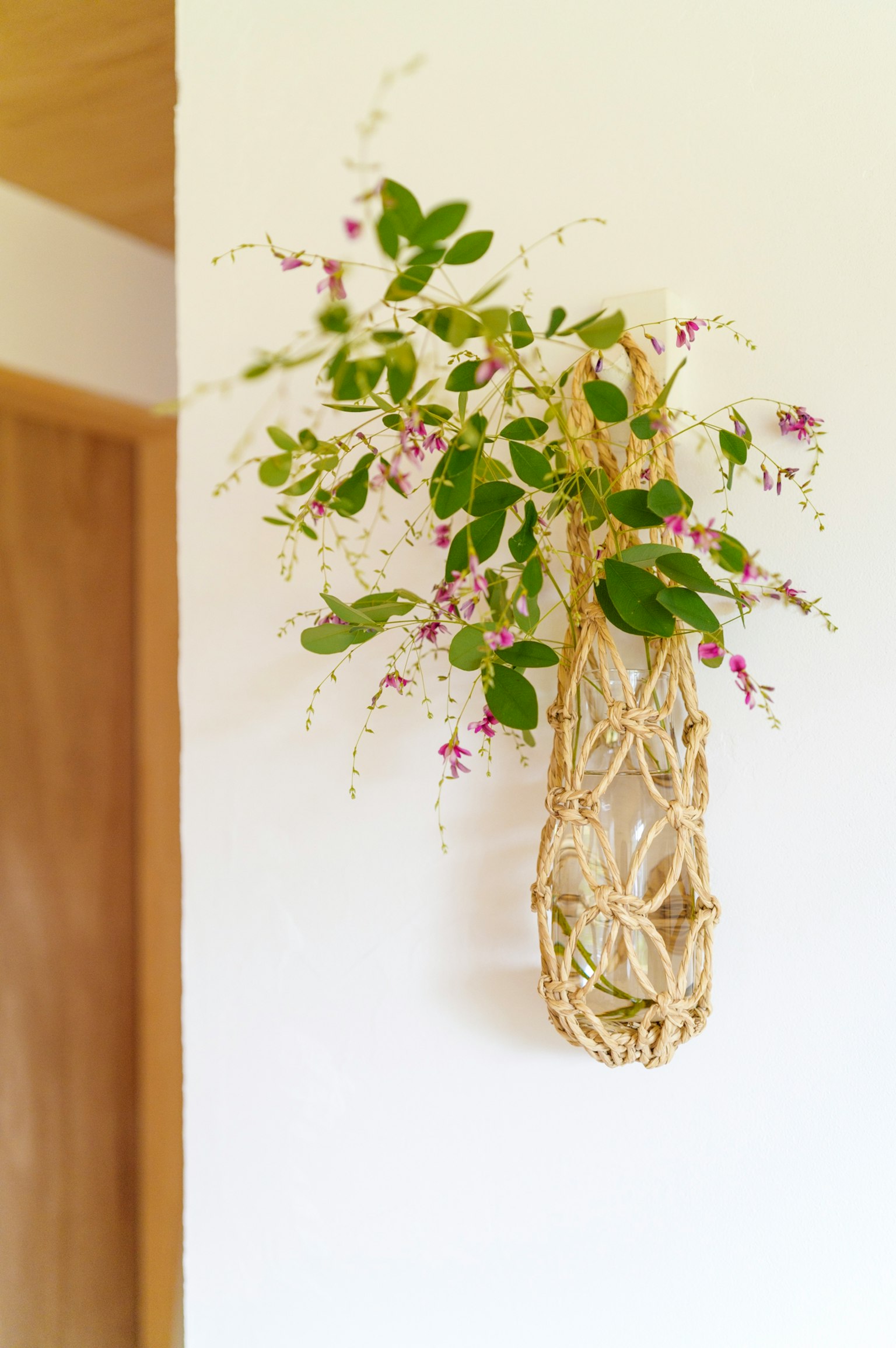 Composizione floreale a parete in un vaso intrecciato naturale