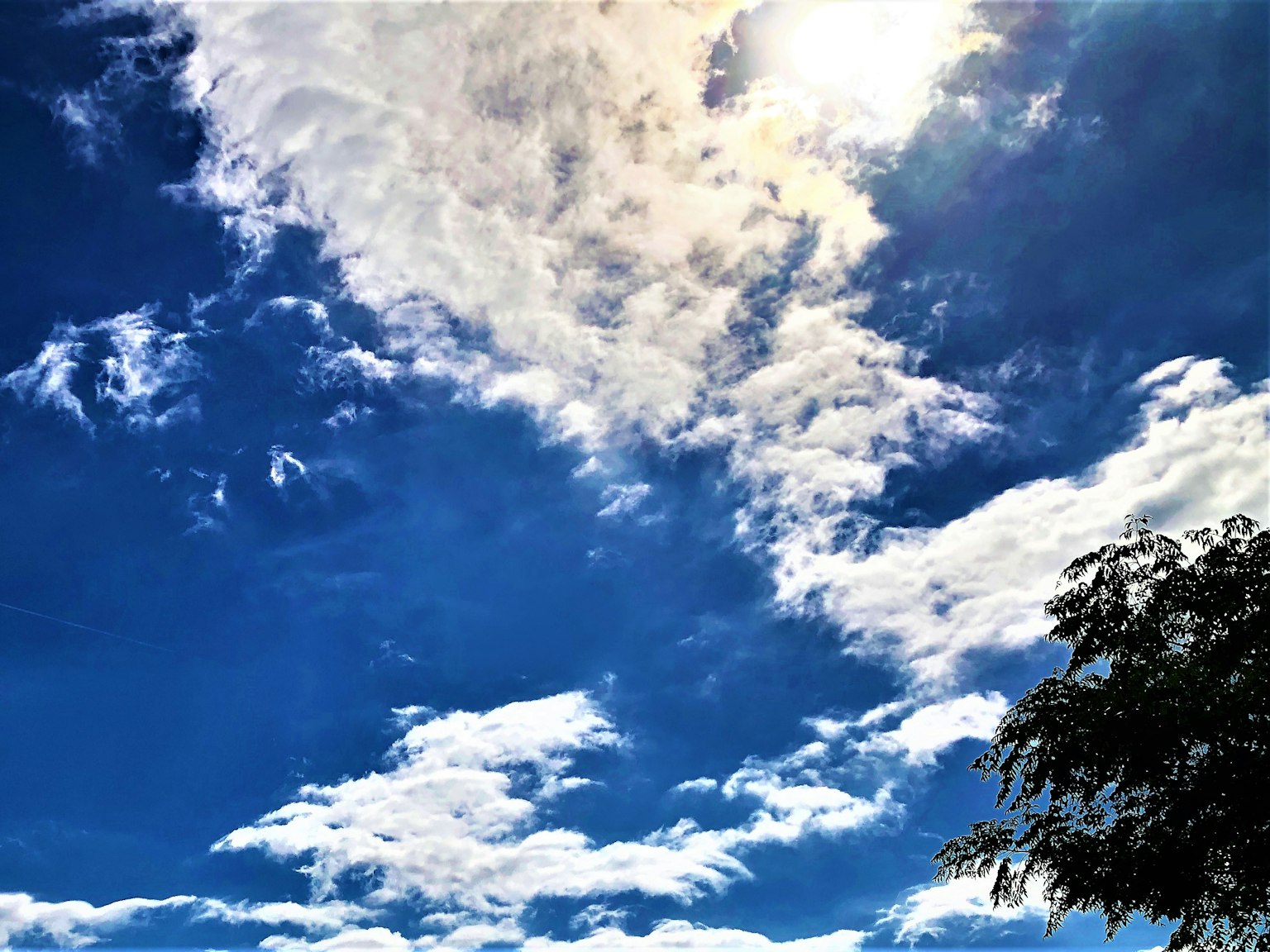 Heller blauer Himmel mit flauschigen weißen Wolken