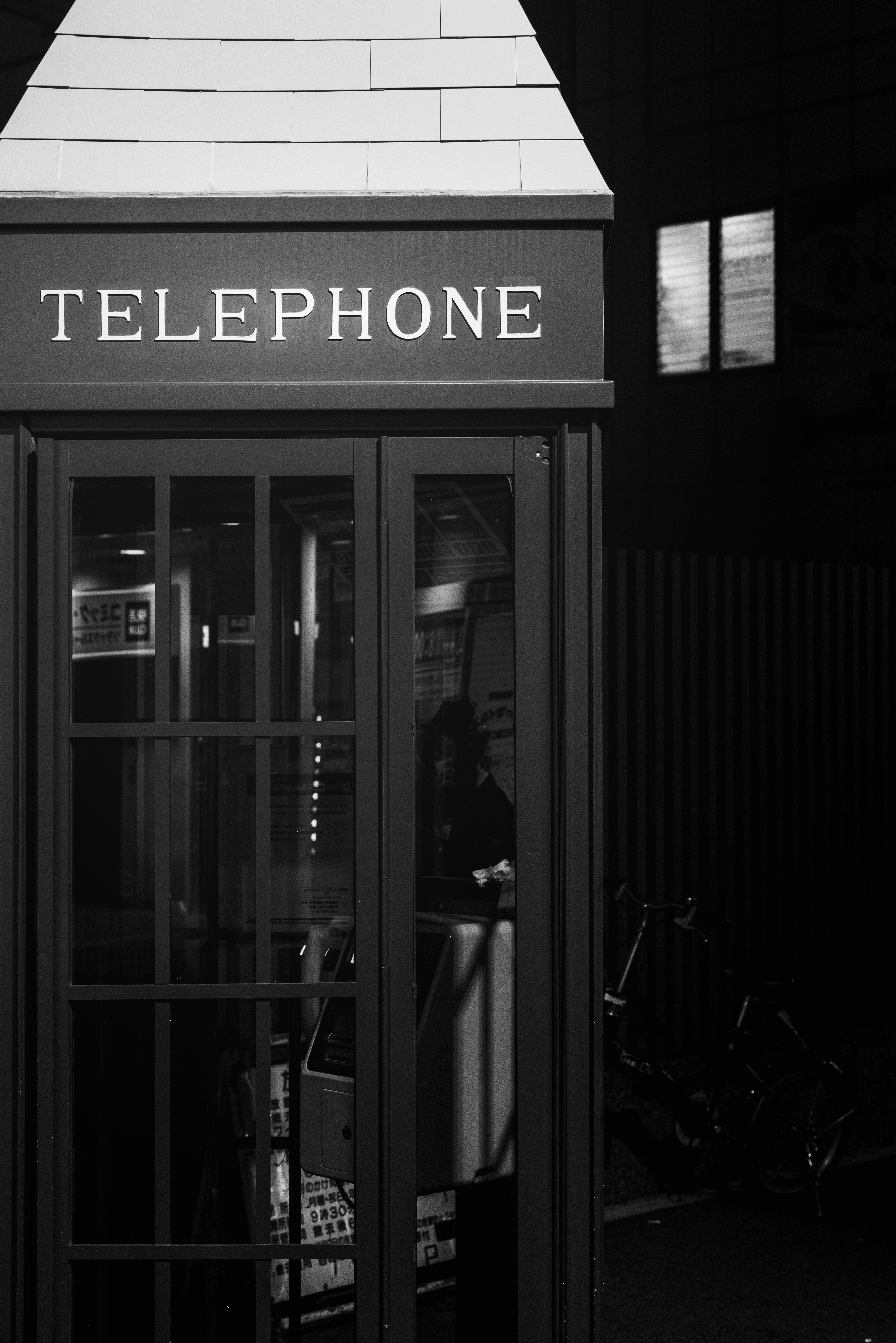 夜更けの電話ボックスのある街角の外観