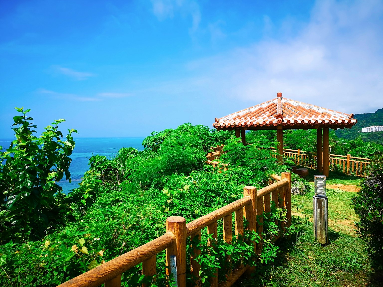 Gazebo tradicional con vista al mar azul rodeado de exuberante vegetación