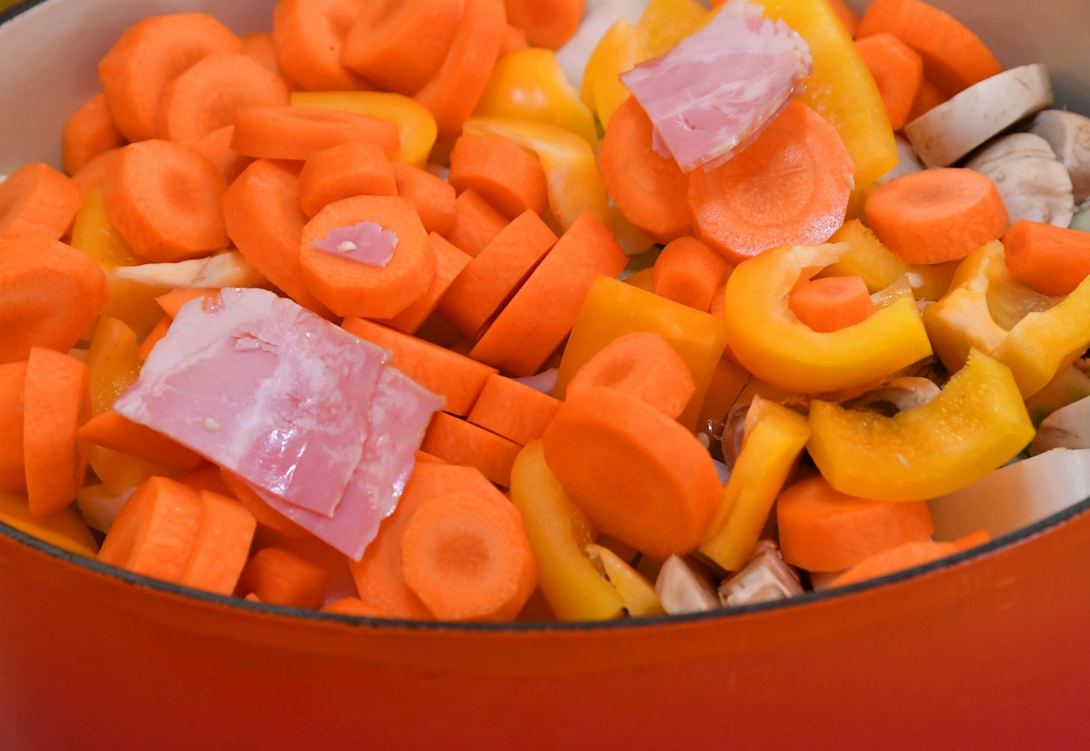 Légumes colorés dans une casserole avec des carottes tranchées et des poivrons jaunes