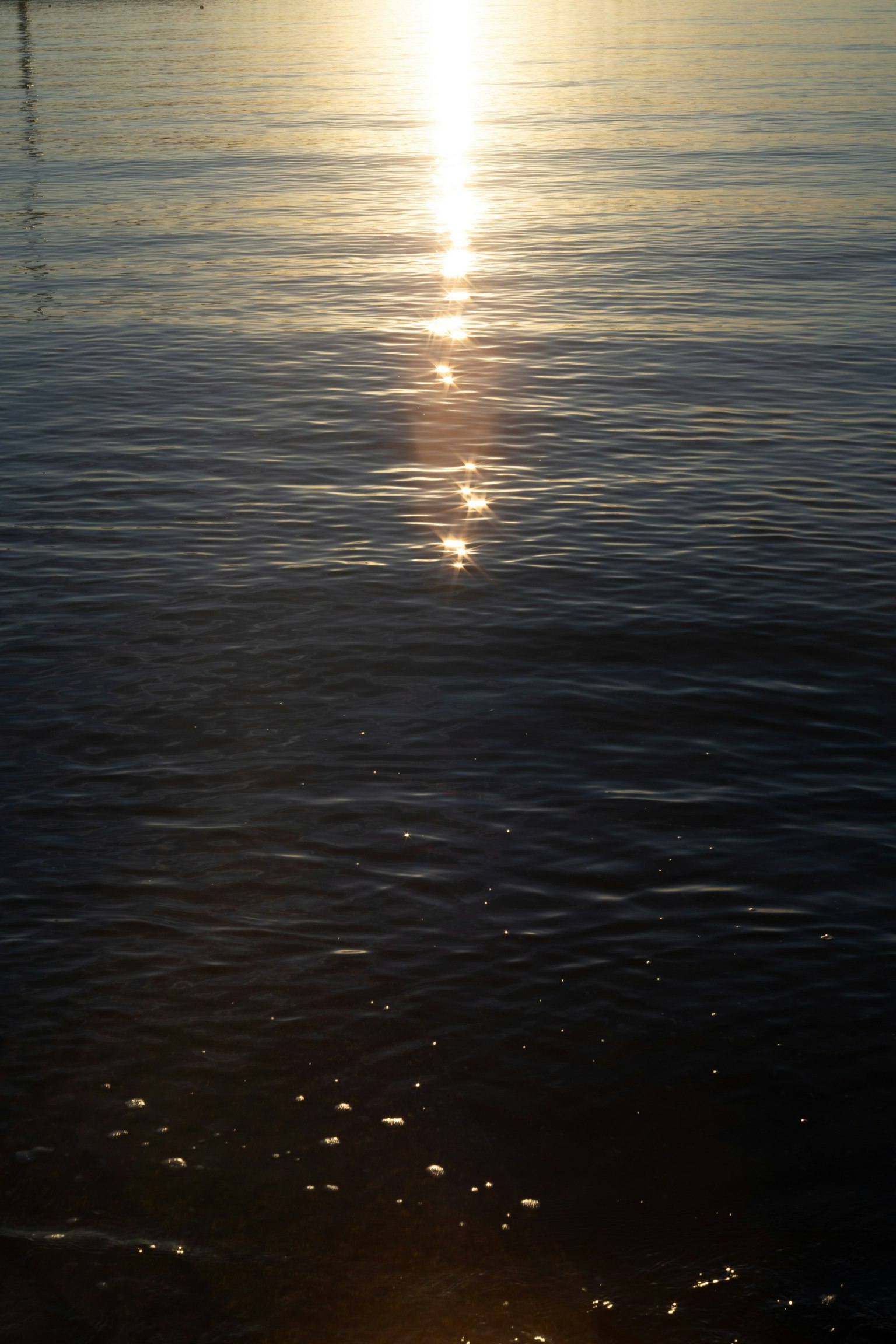 Reflejo de la luz del sol en la superficie del agua tranquila