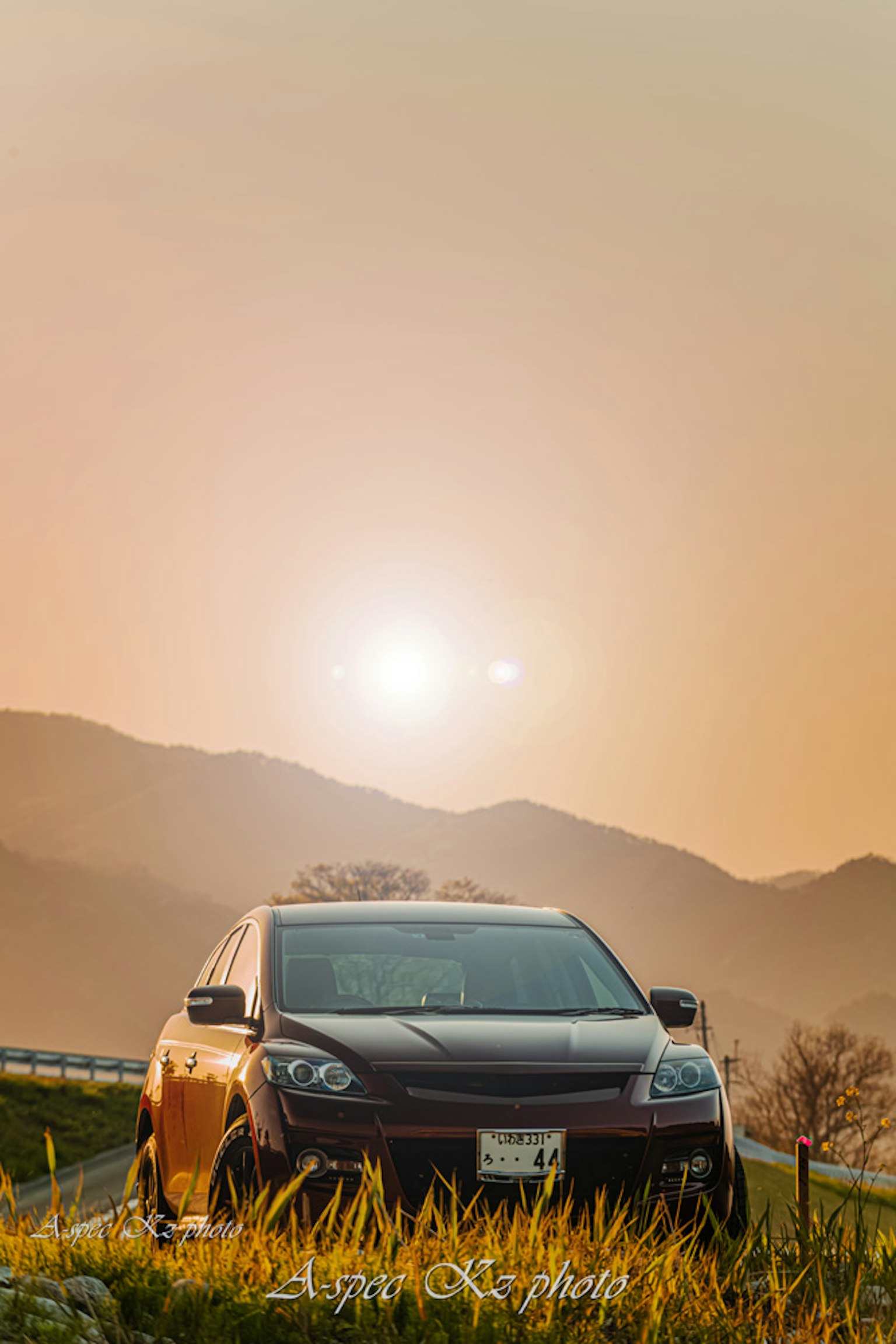 Schwarzes Auto vor Bergen mit Sonnenuntergangshimmel