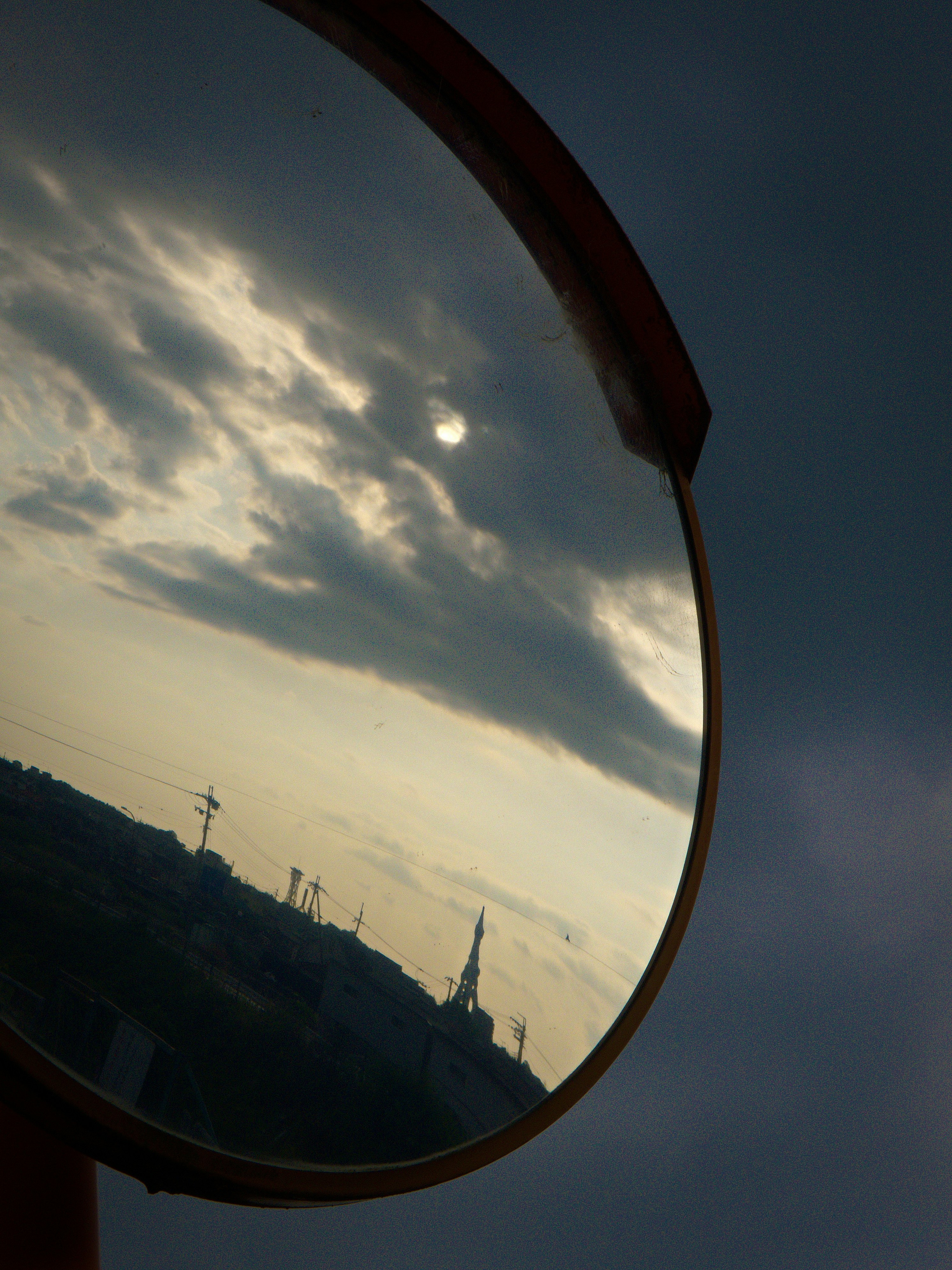 Sonnenuntergangshimmel mit Wolken durch einen gebogenen Spiegel