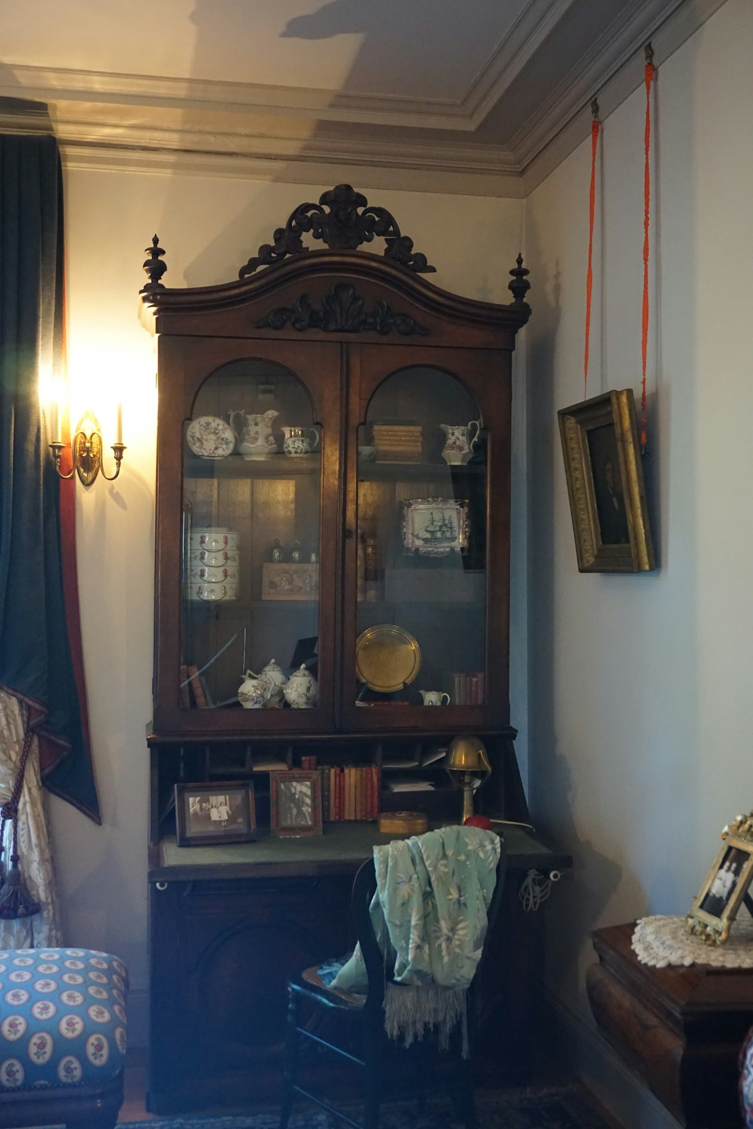 Un armadio vintage che espone ceramiche e libri in un angolo della stanza