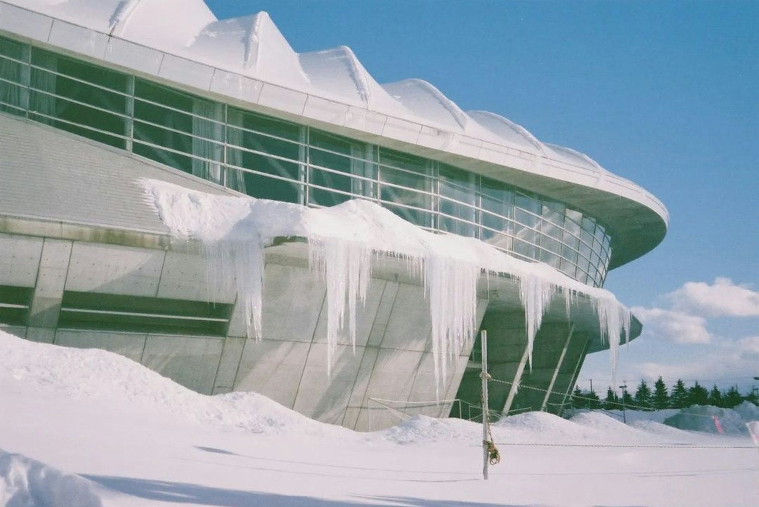 現代建築被雪覆蓋，懸掛著冰柱