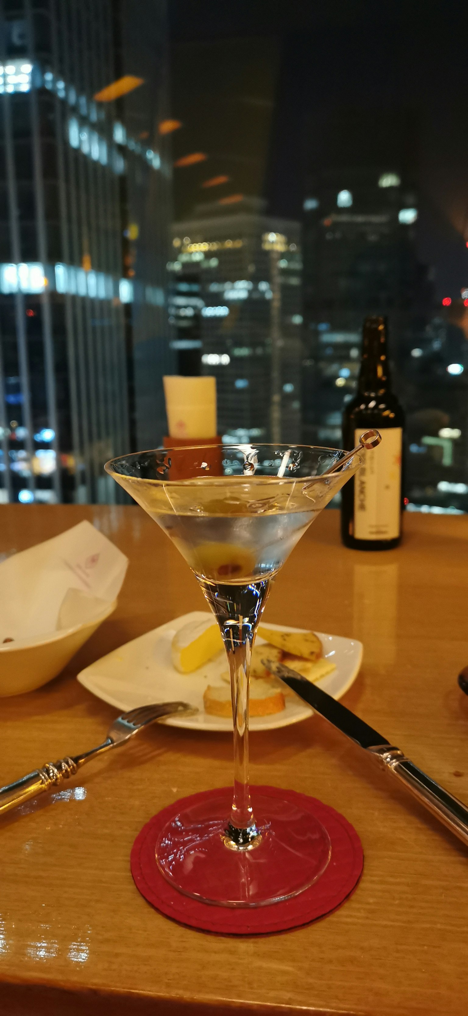 夜景背景下的馬提尼酒杯和餐飲物品