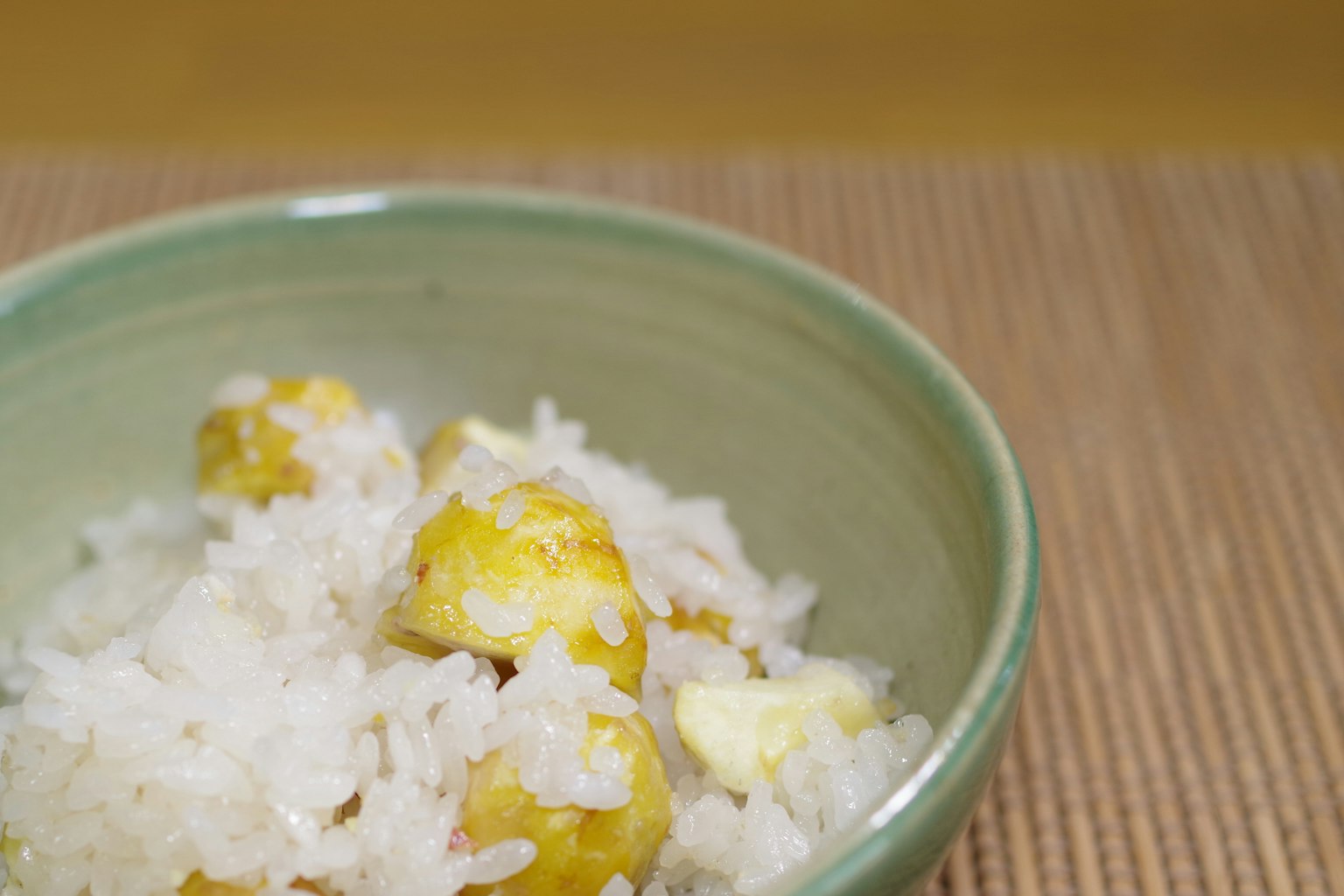Mangkuk hijau berisi nasi putih dan bahan kuning