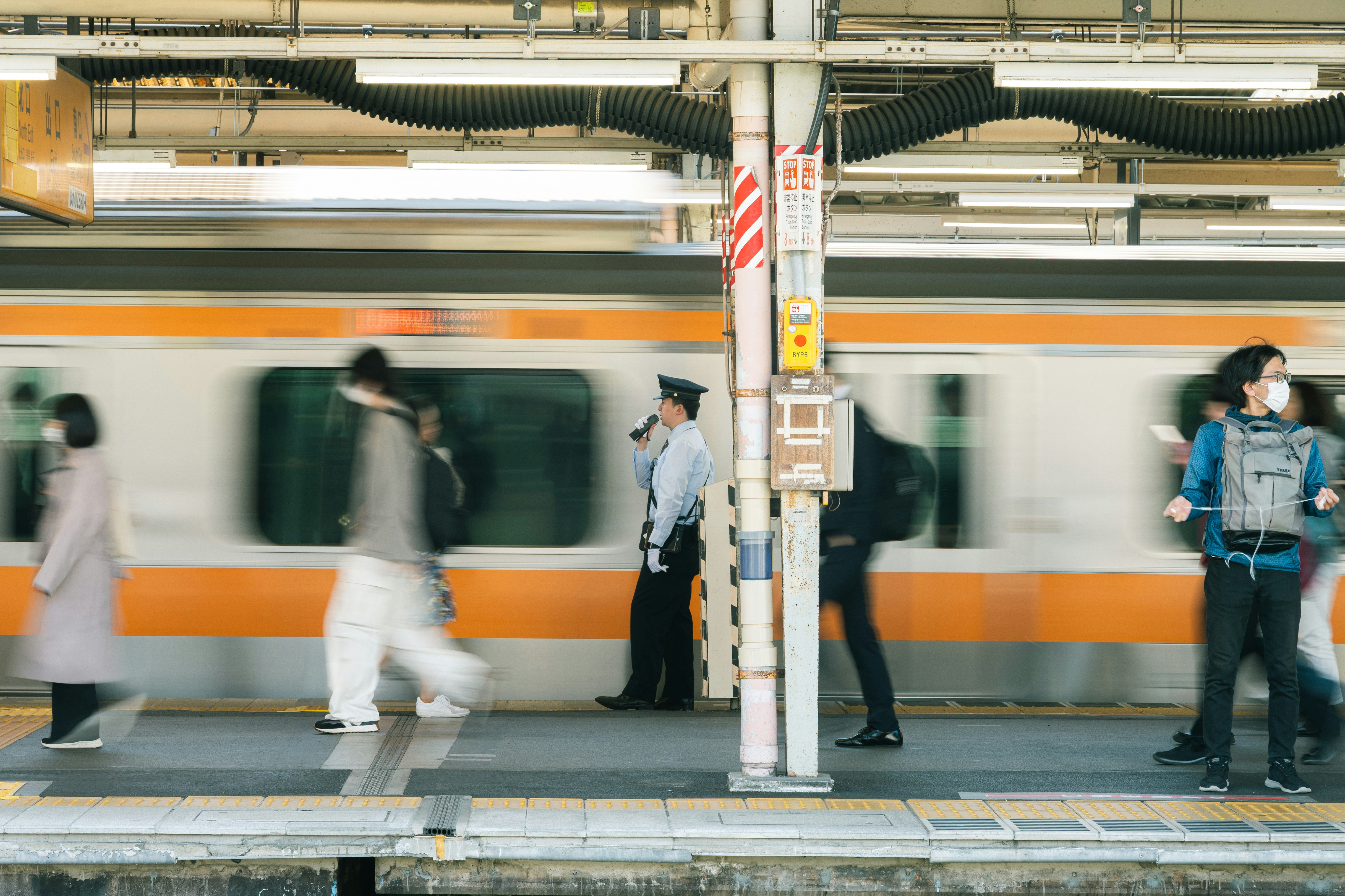 駅のホームで行き交う人々と電車
