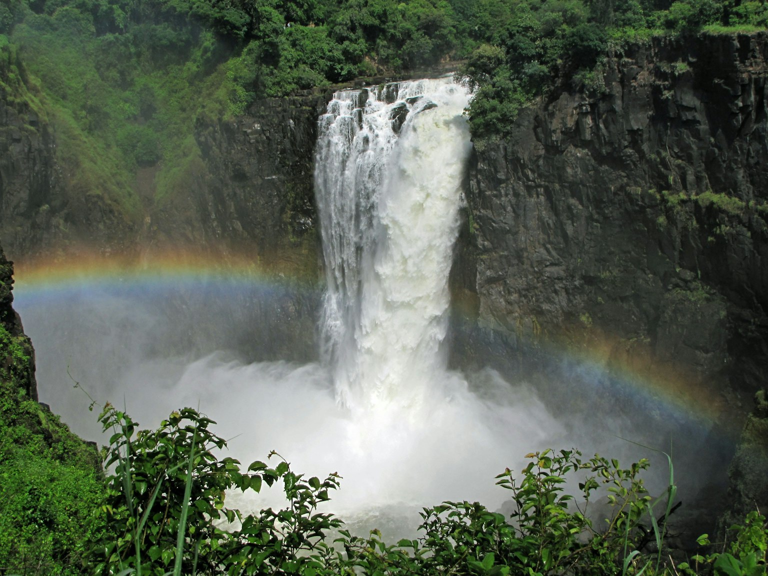 Sebuah air terjun yang menakjubkan dengan pelangi yang terlihat