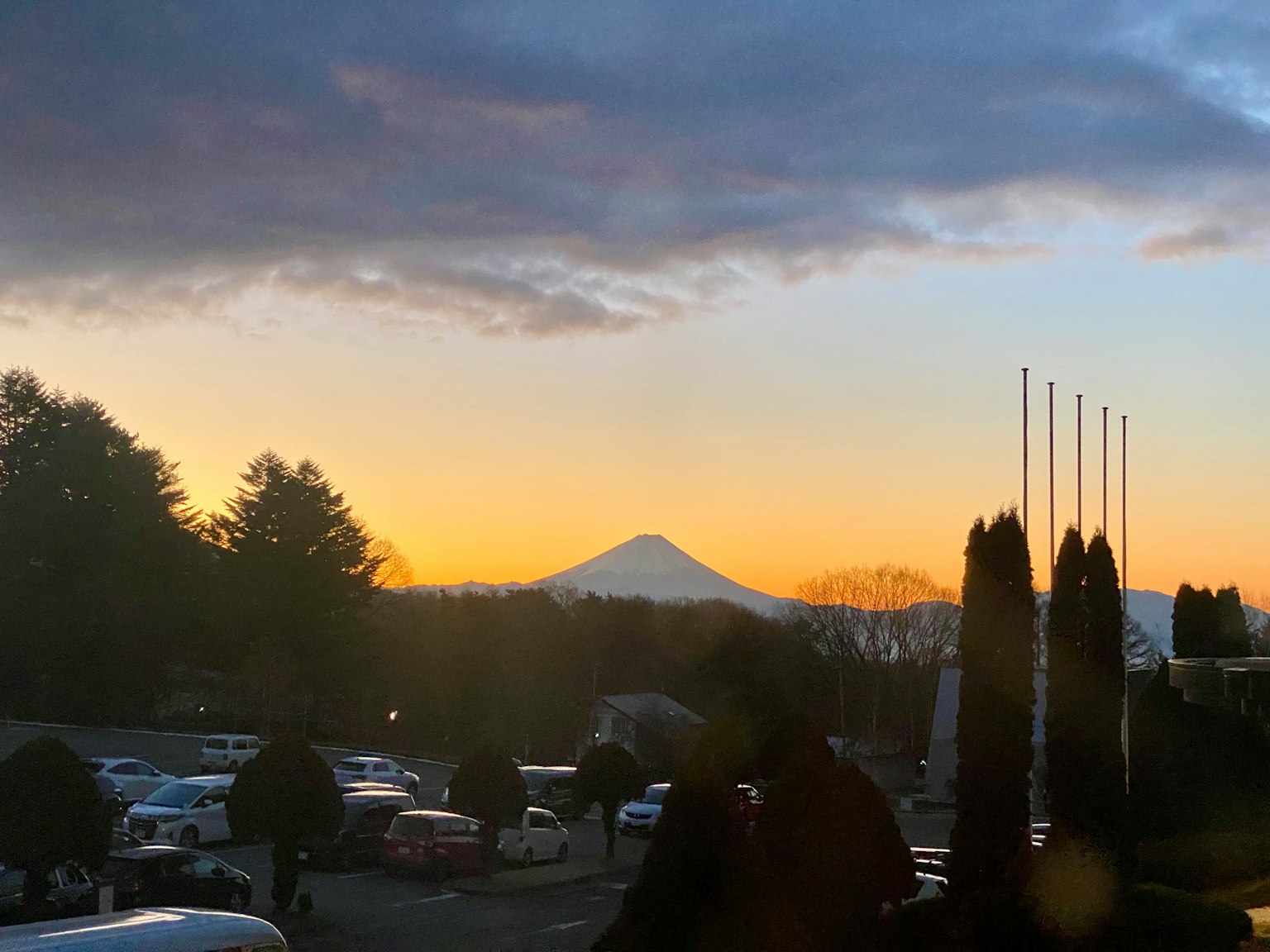 富士山在多彩的日落和周圍樹木的衬托下