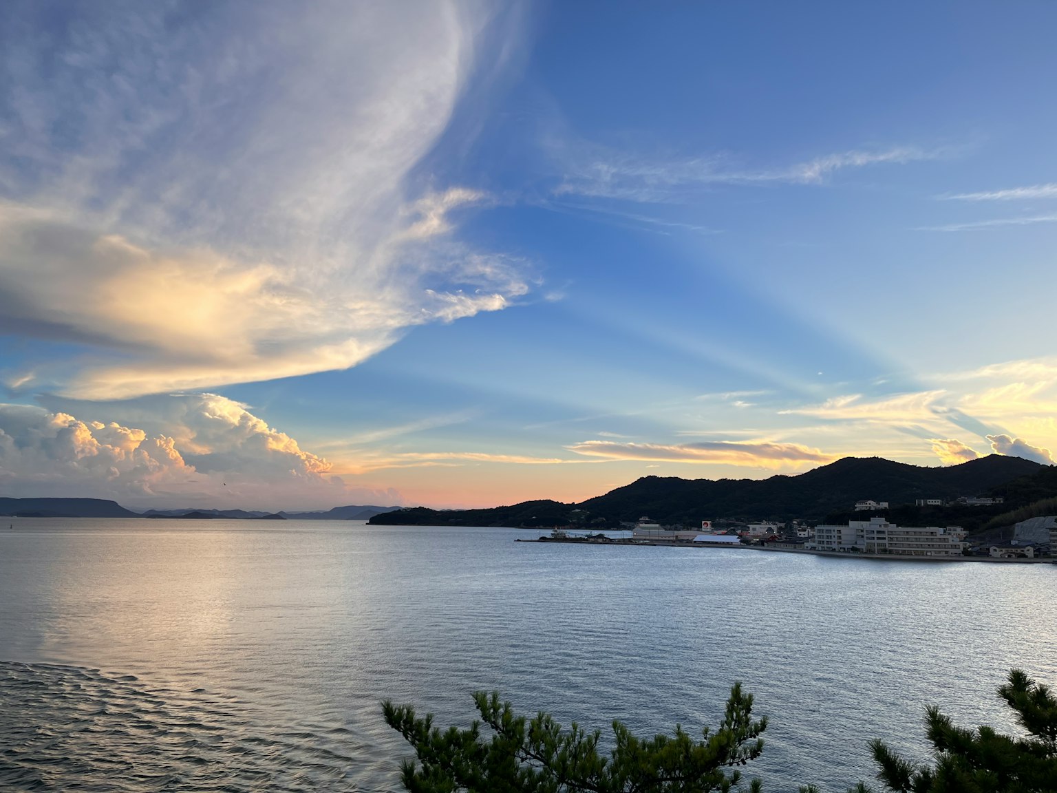 Malersicher Blick auf das Meer mit blauem Himmel Wolken bei Sonnenuntergang Silhouette von Bergen