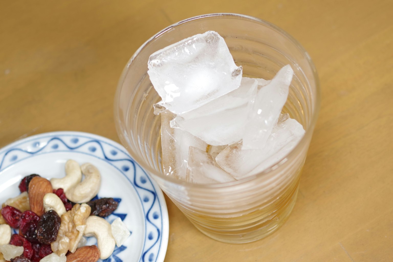 Verre transparent avec des glaçons et une assiette de collations