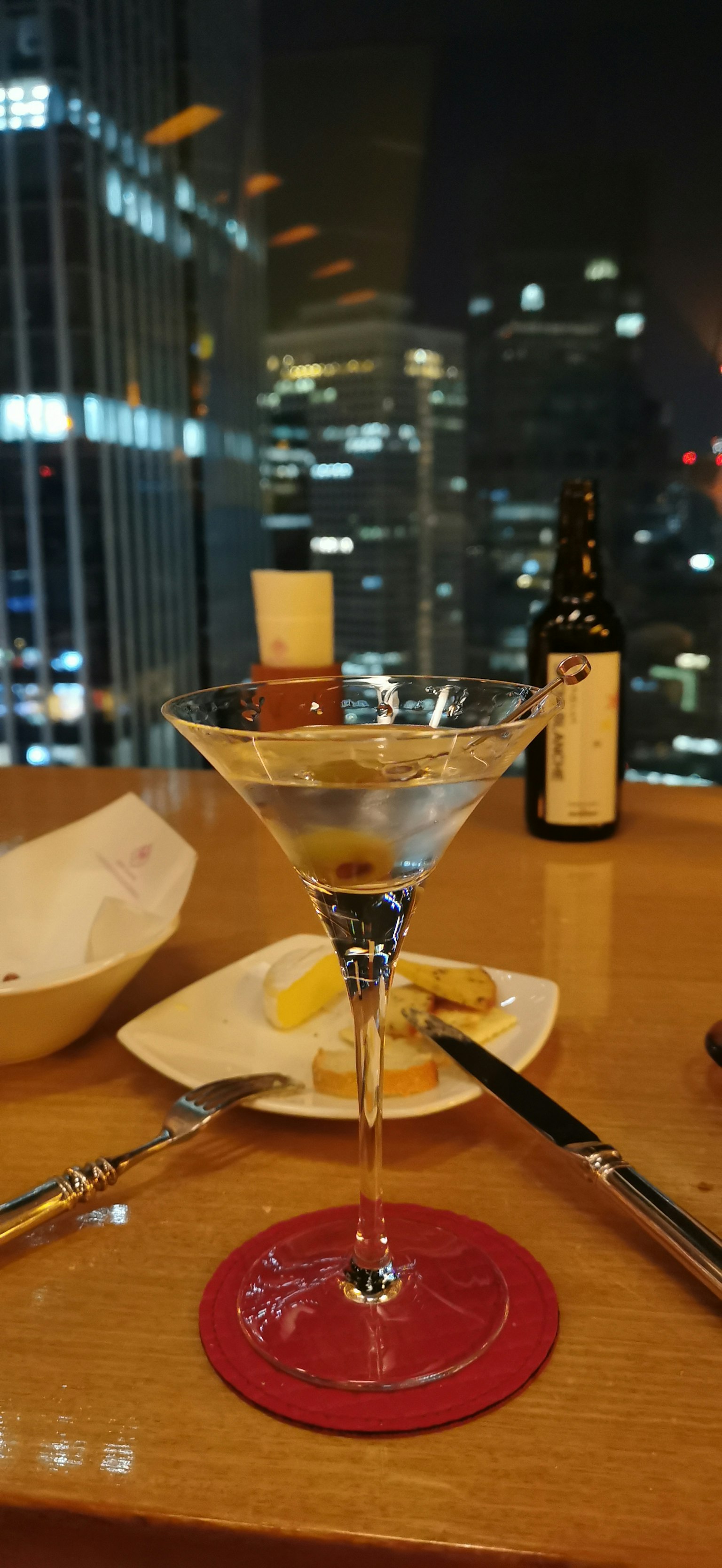 Ly martini với đường chân trời thành phố vào ban đêm