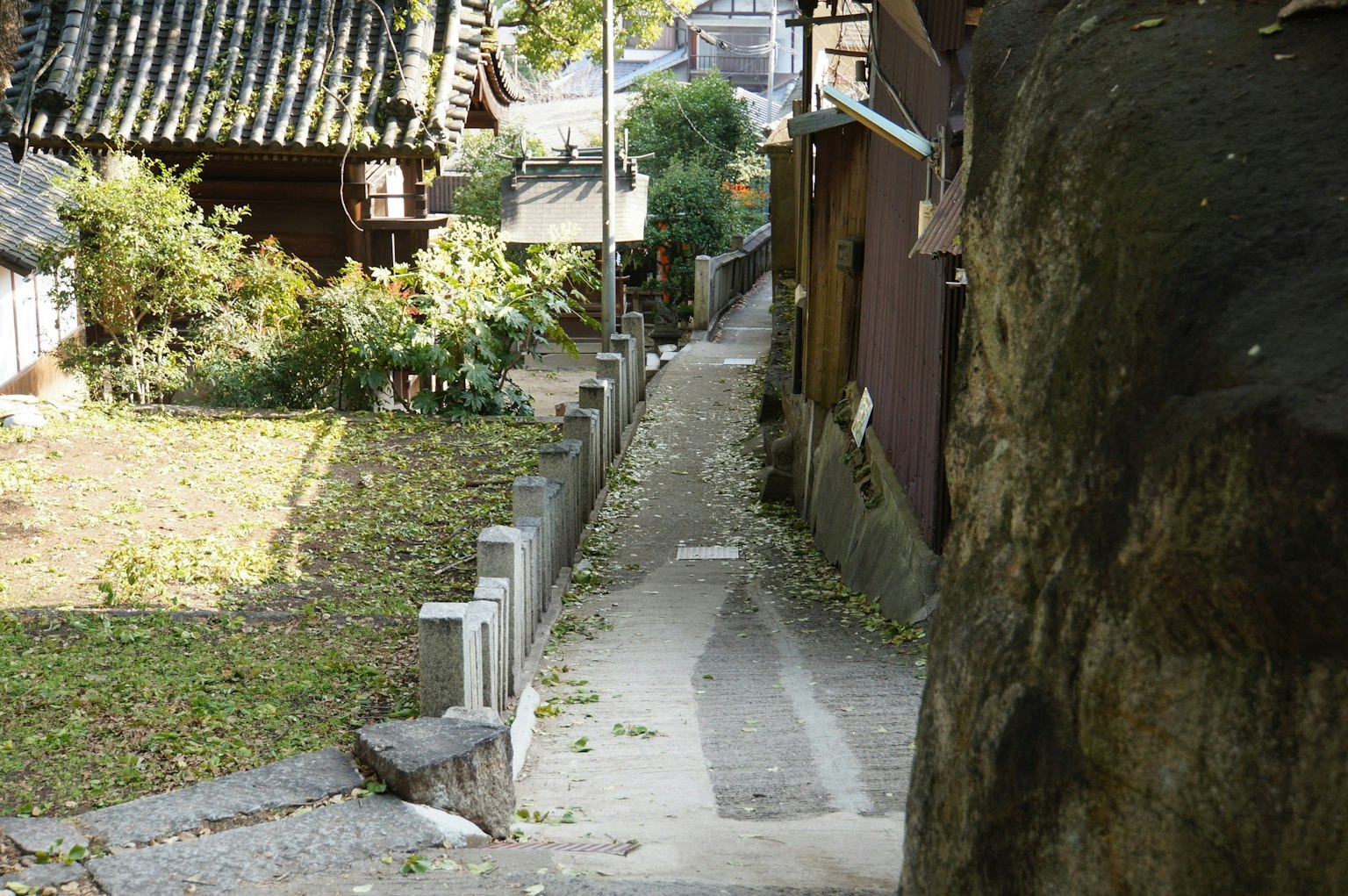 เส้นทางแคบในเมืองญี่ปุ่นโบราณที่มีพืชพรรณรอบๆ