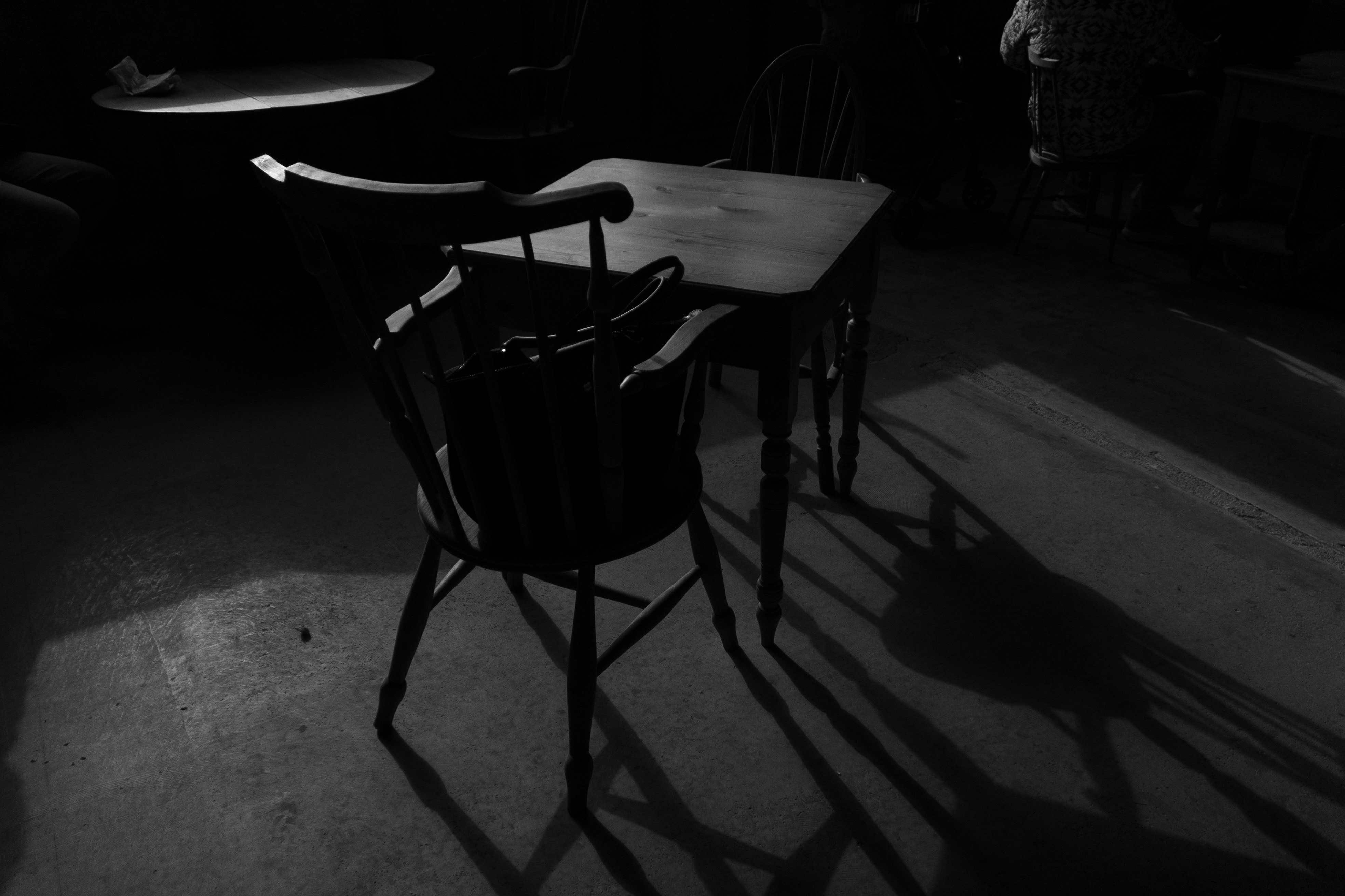 quiet indoor scene with a table and chairs in the dark